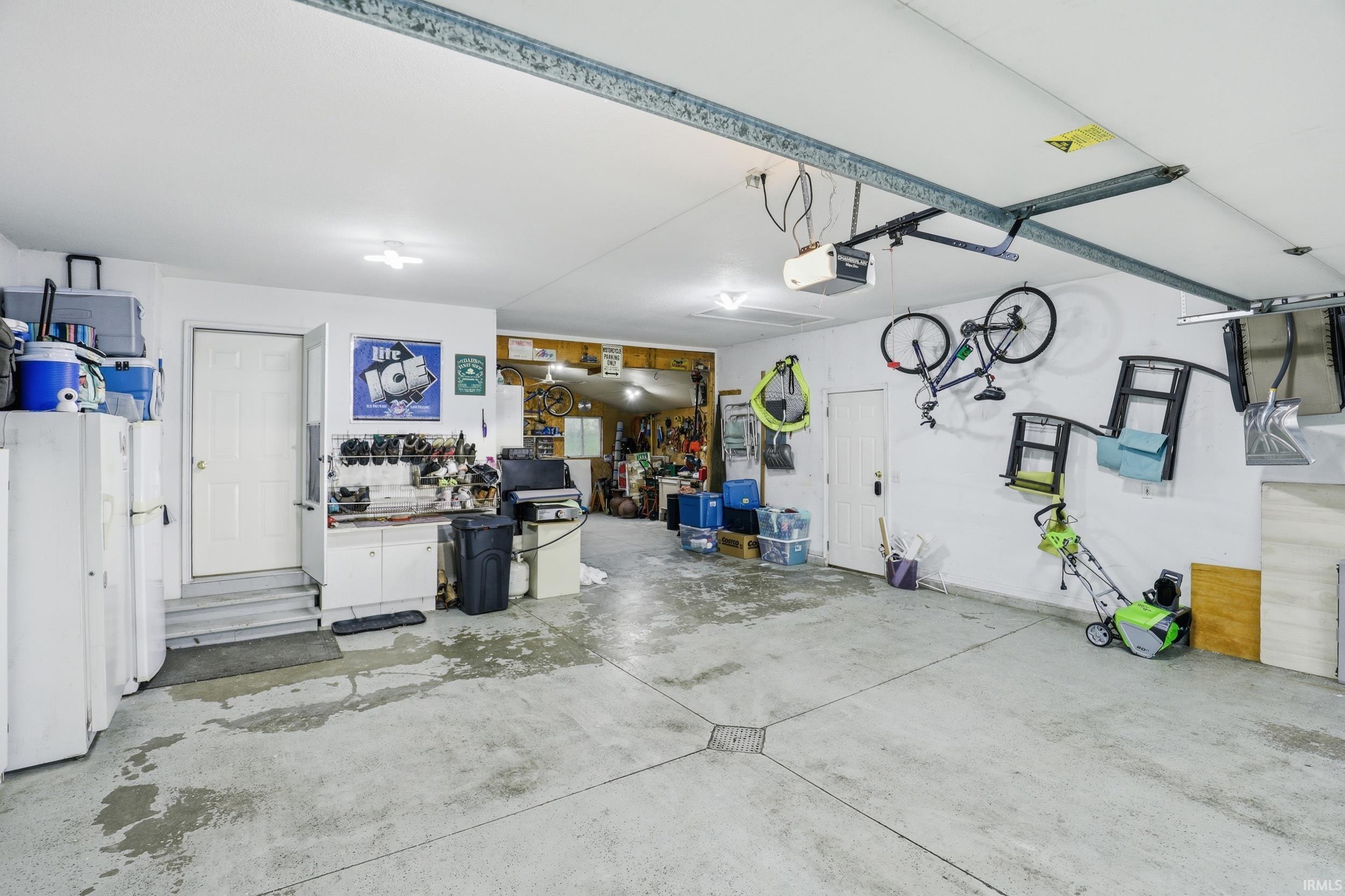Garage featuring freestanding refrigerator and a garage door opener