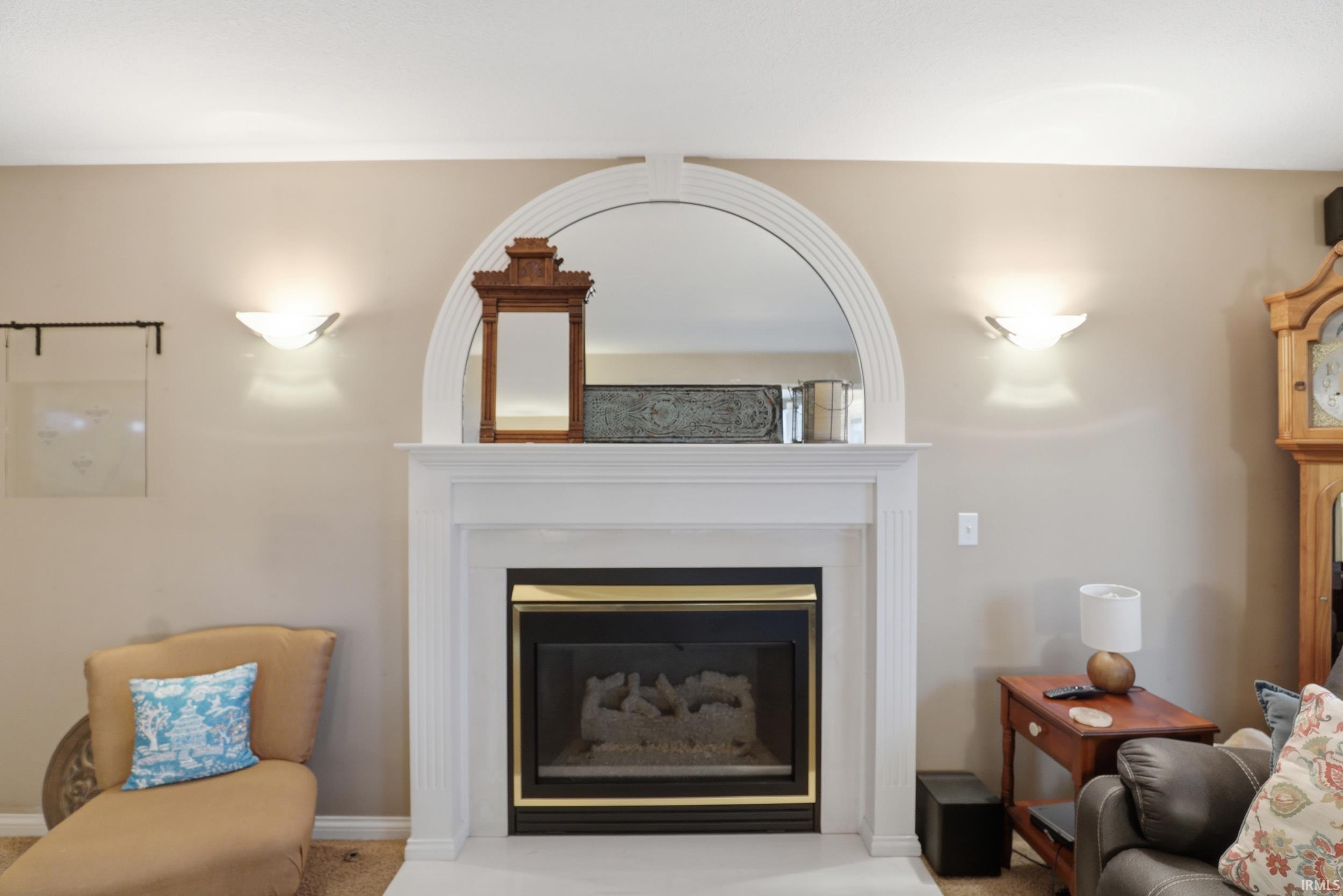 Living area with a glass covered fireplace and light carpet