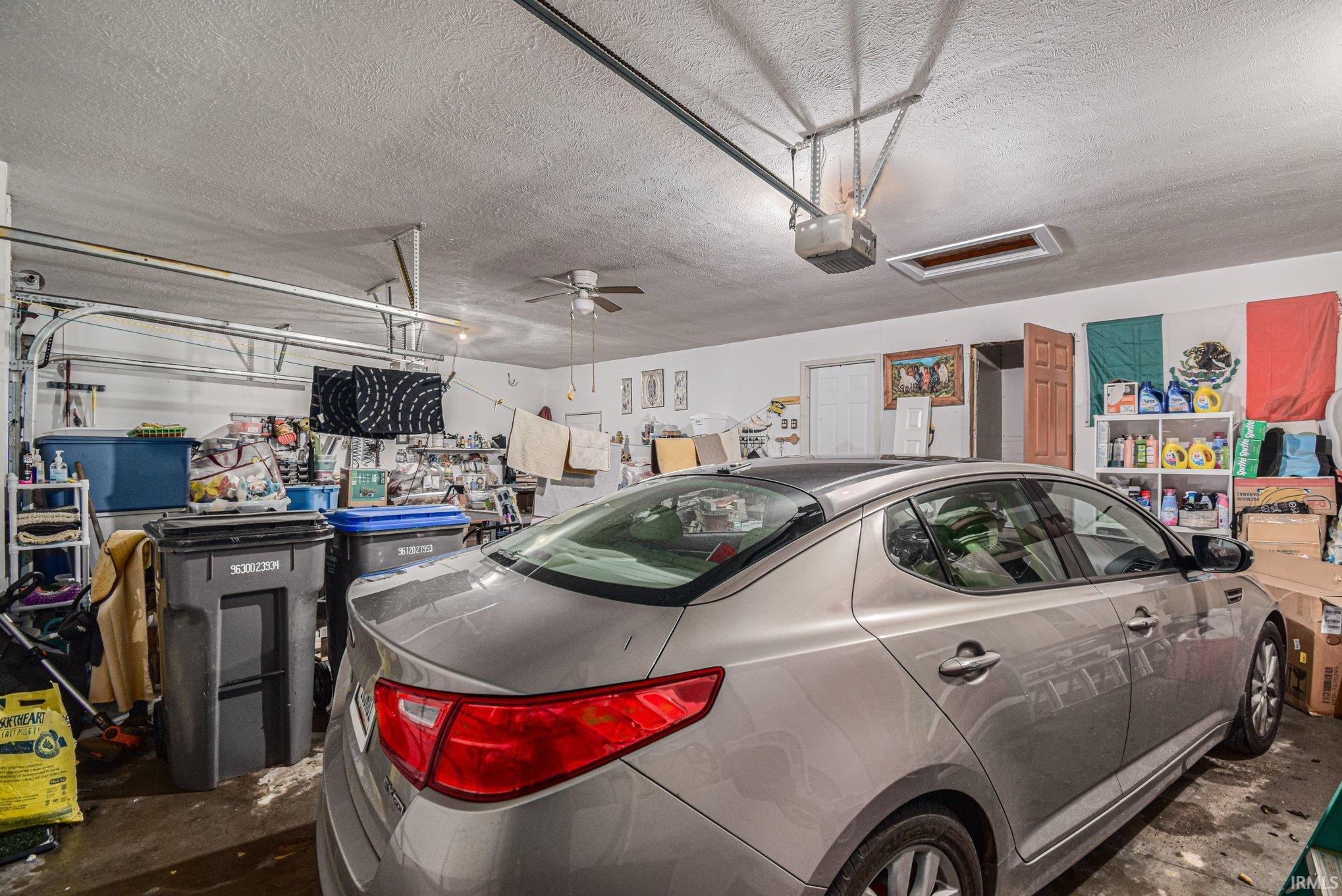 Garage featuring ceiling fan and a garage door opener