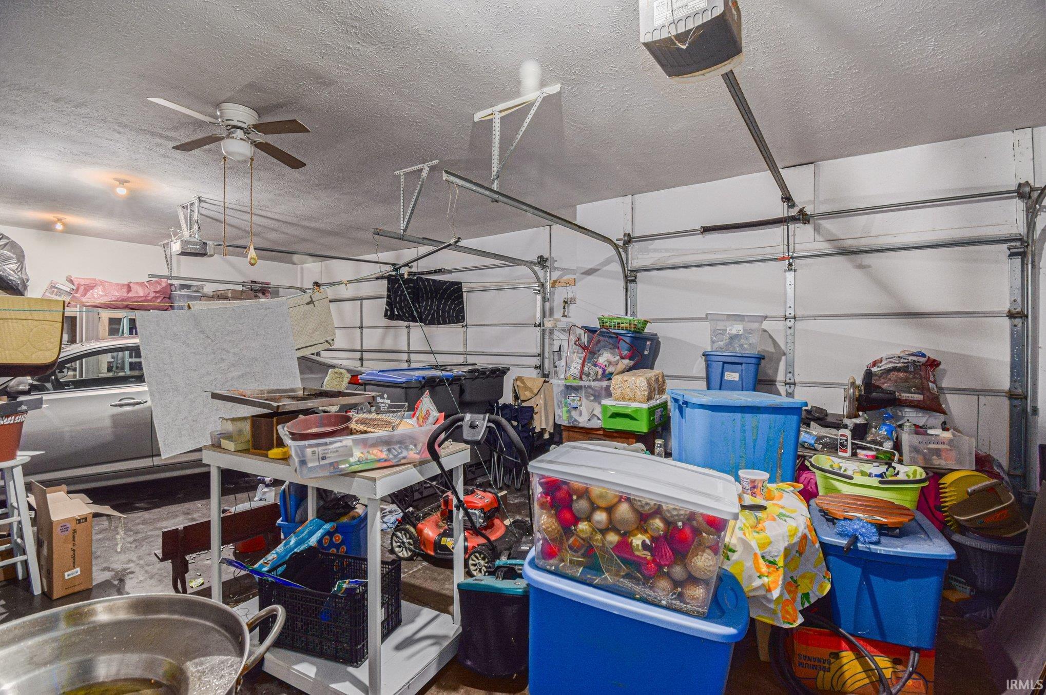 Garage with a garage door opener and a ceiling fan