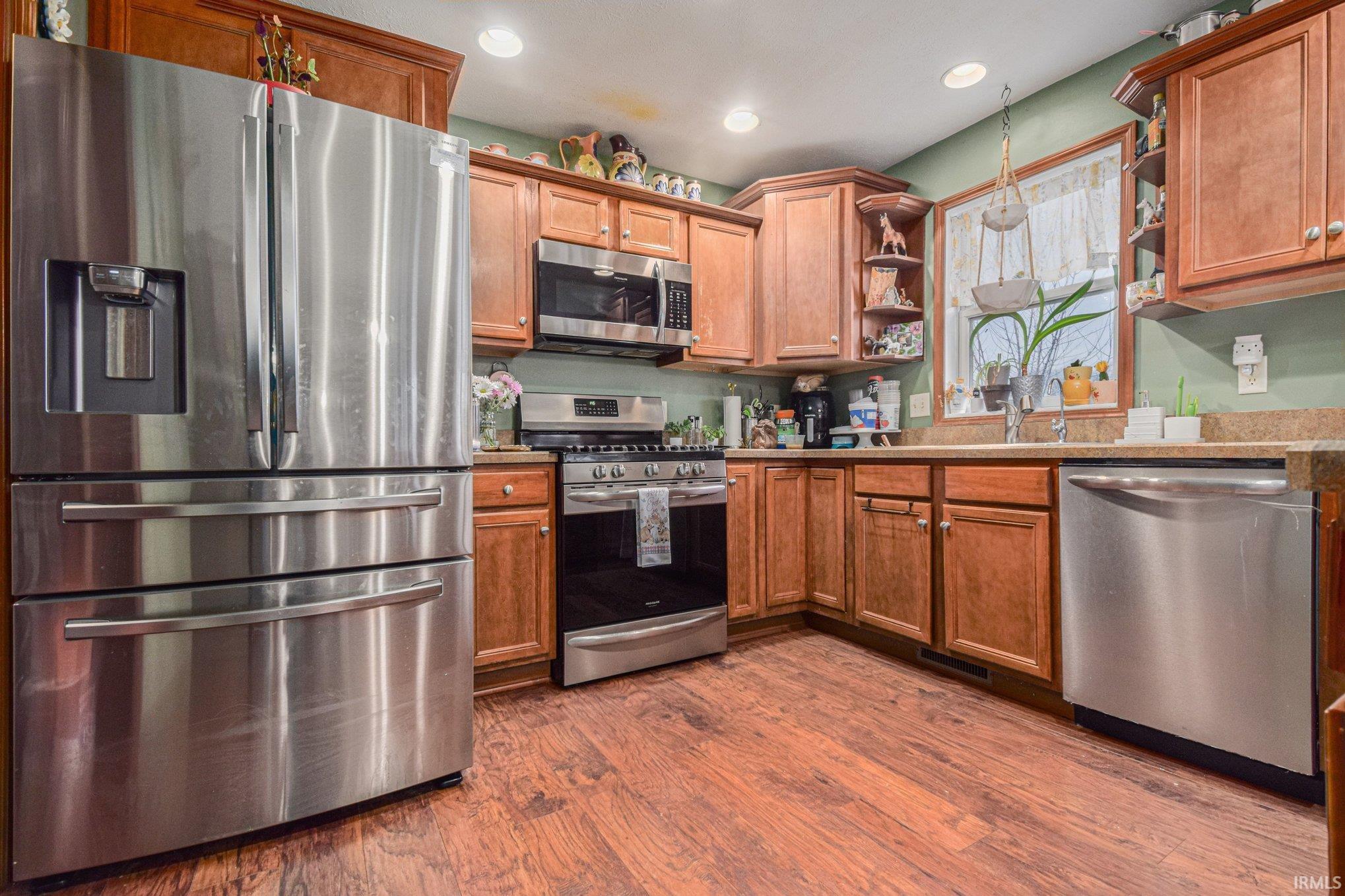 Kitchen featuring open shelves, stainless steel appliances, wood finish cabinets, dark wood-type flooring, and recessed lighting