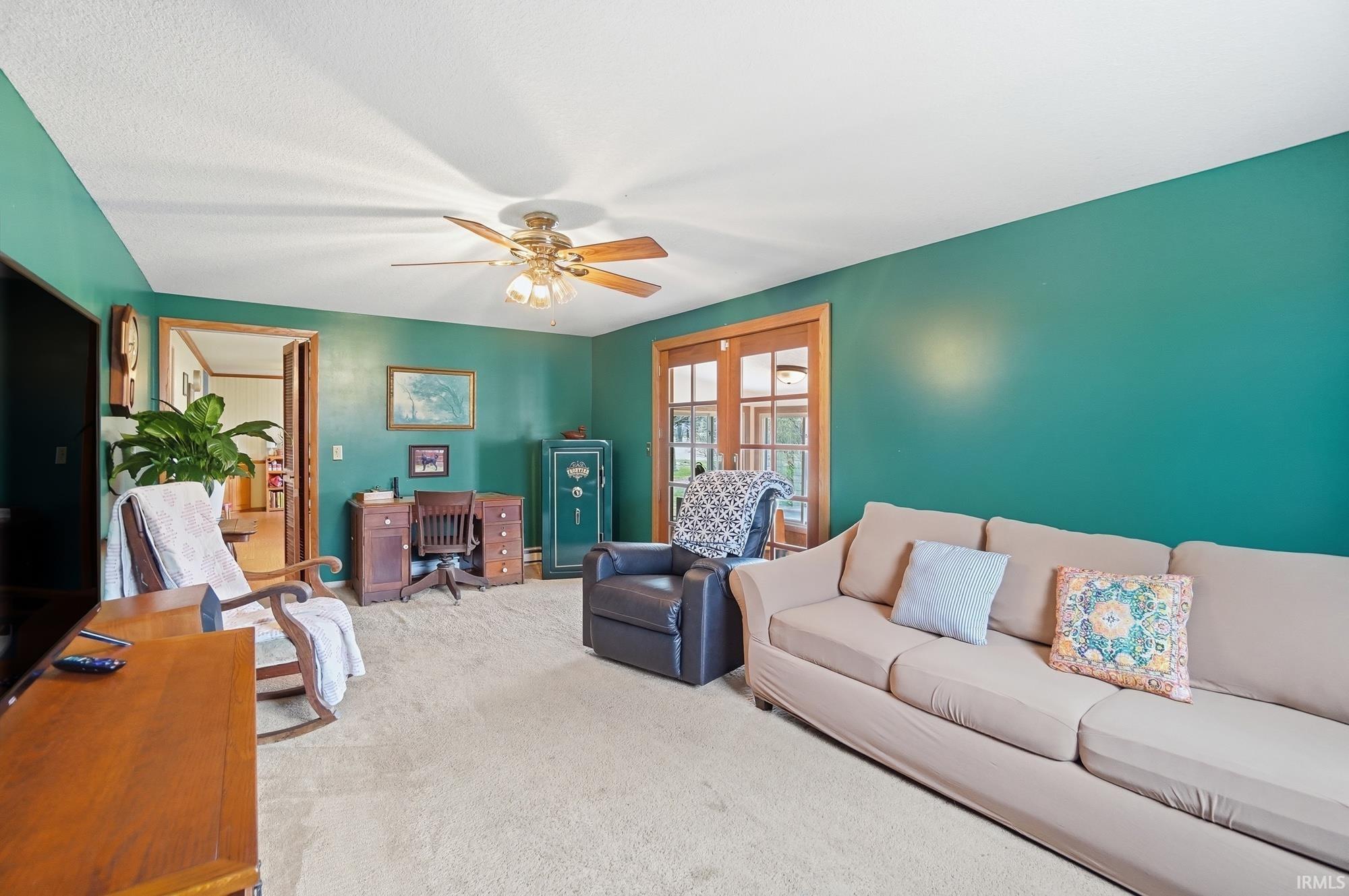 Carpeted living room with ceiling fan