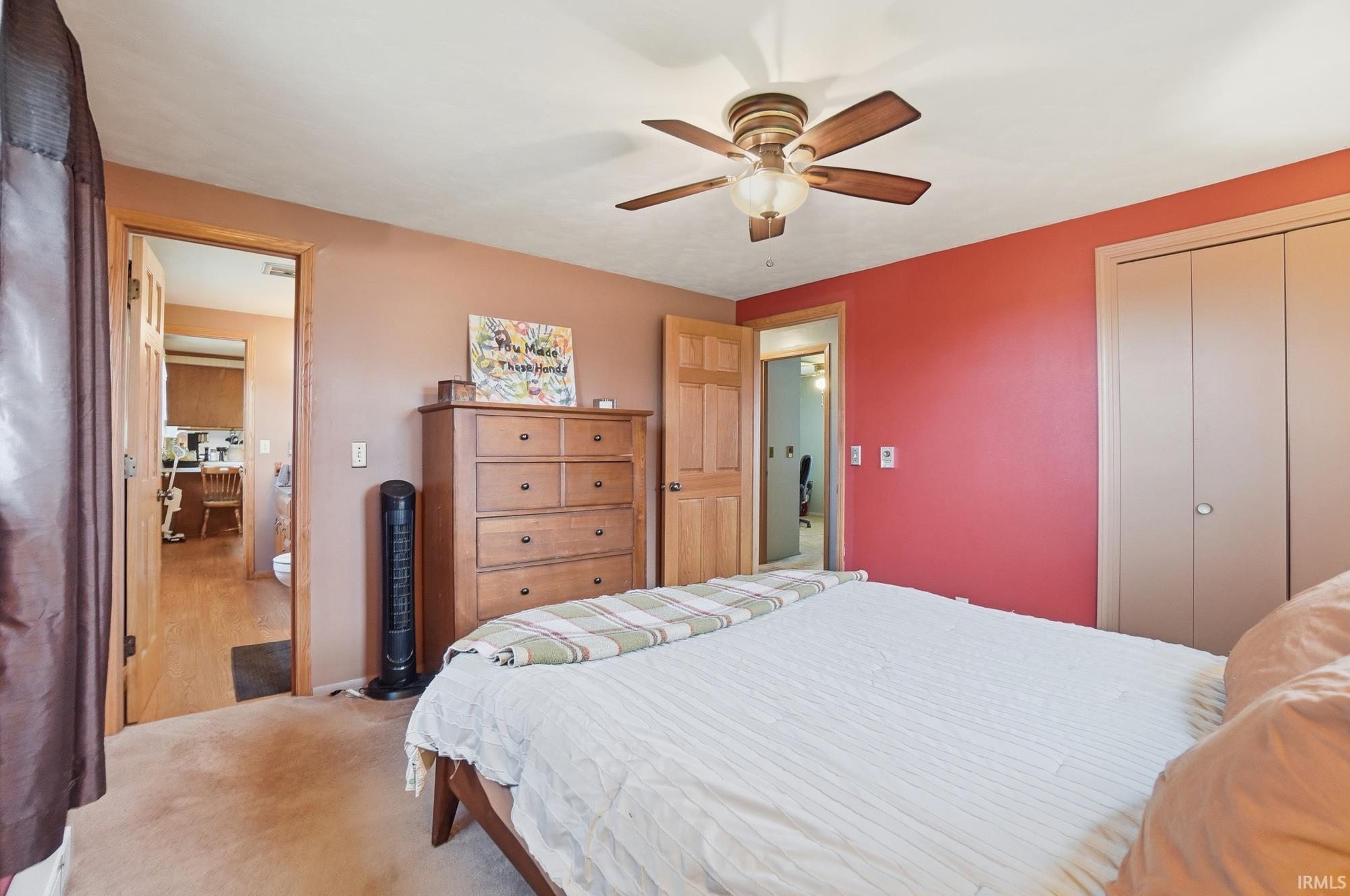 Bedroom with carpet, a closet, and a ceiling fan