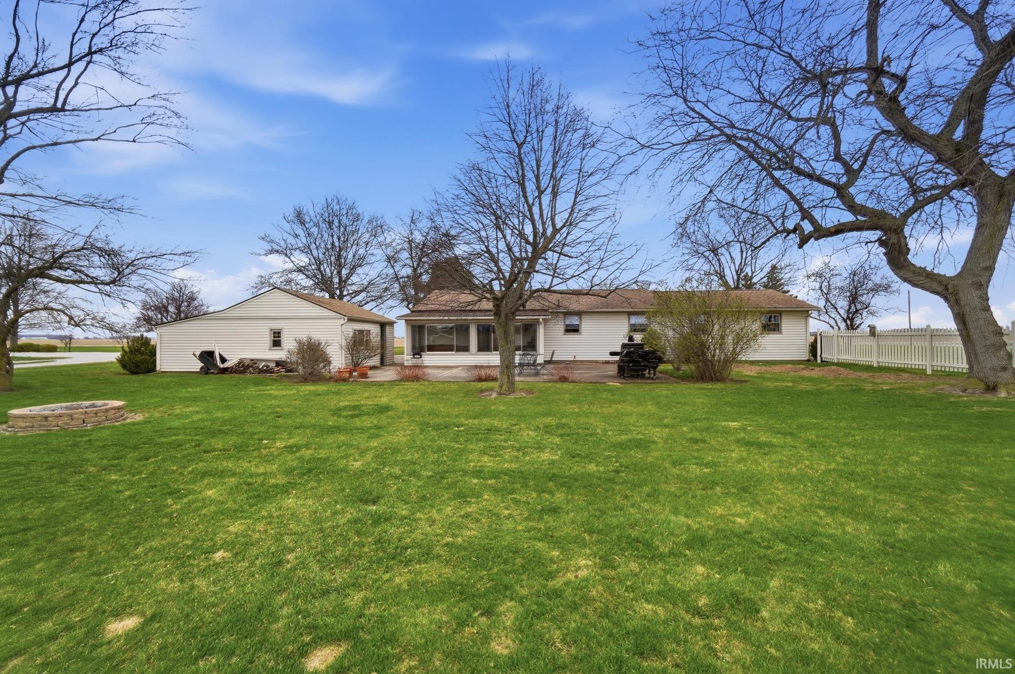 Rear view of property with a patio area and a fire pit