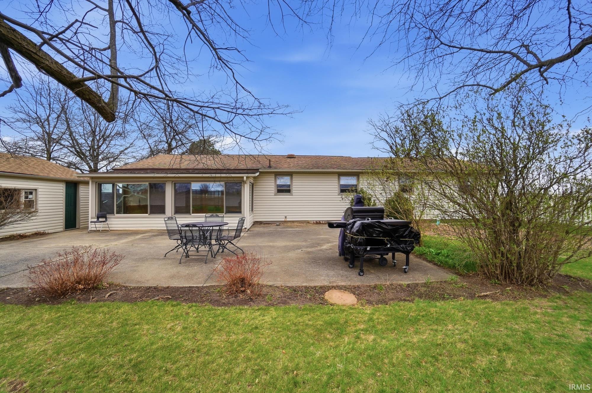 Back of property featuring a patio area, a yard, and outdoor dining space