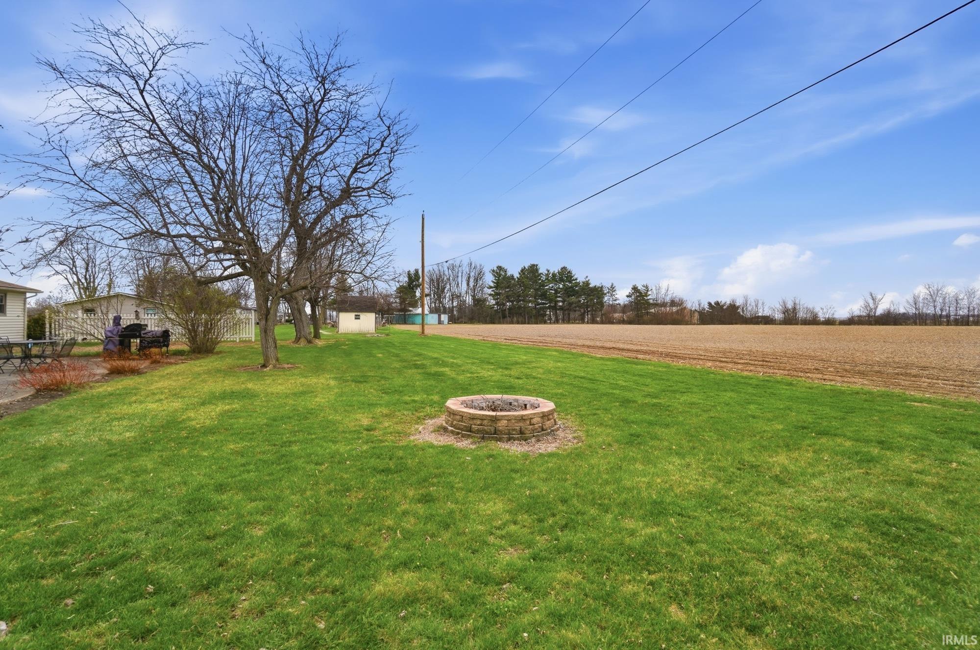 View of grassy yard with a fire pit