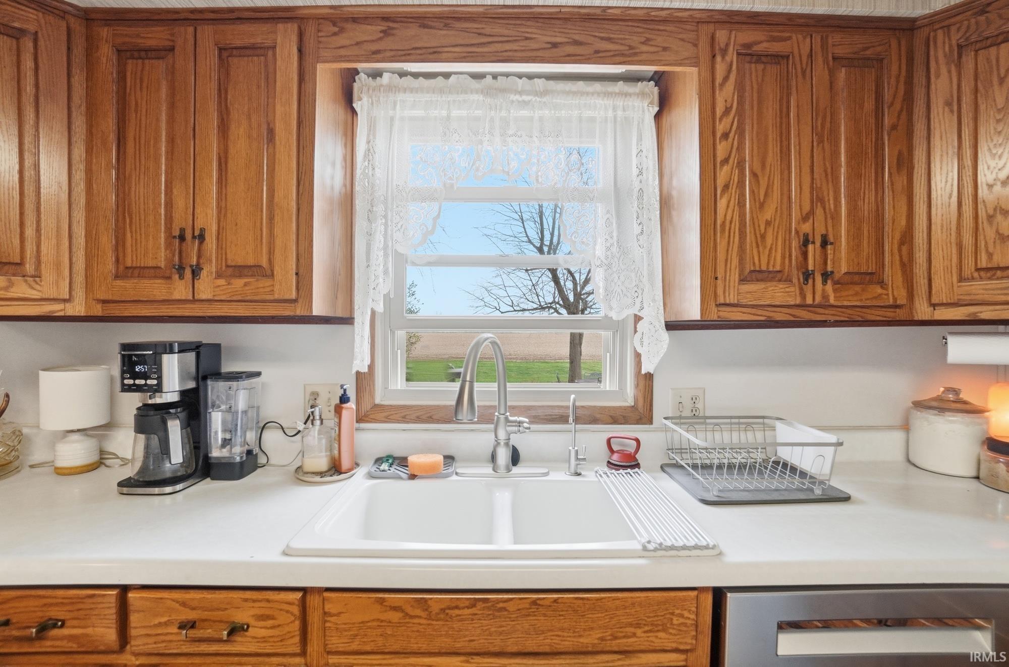 Kitchen with wood finish cabinets, light countertops, and healthy amount of natural light