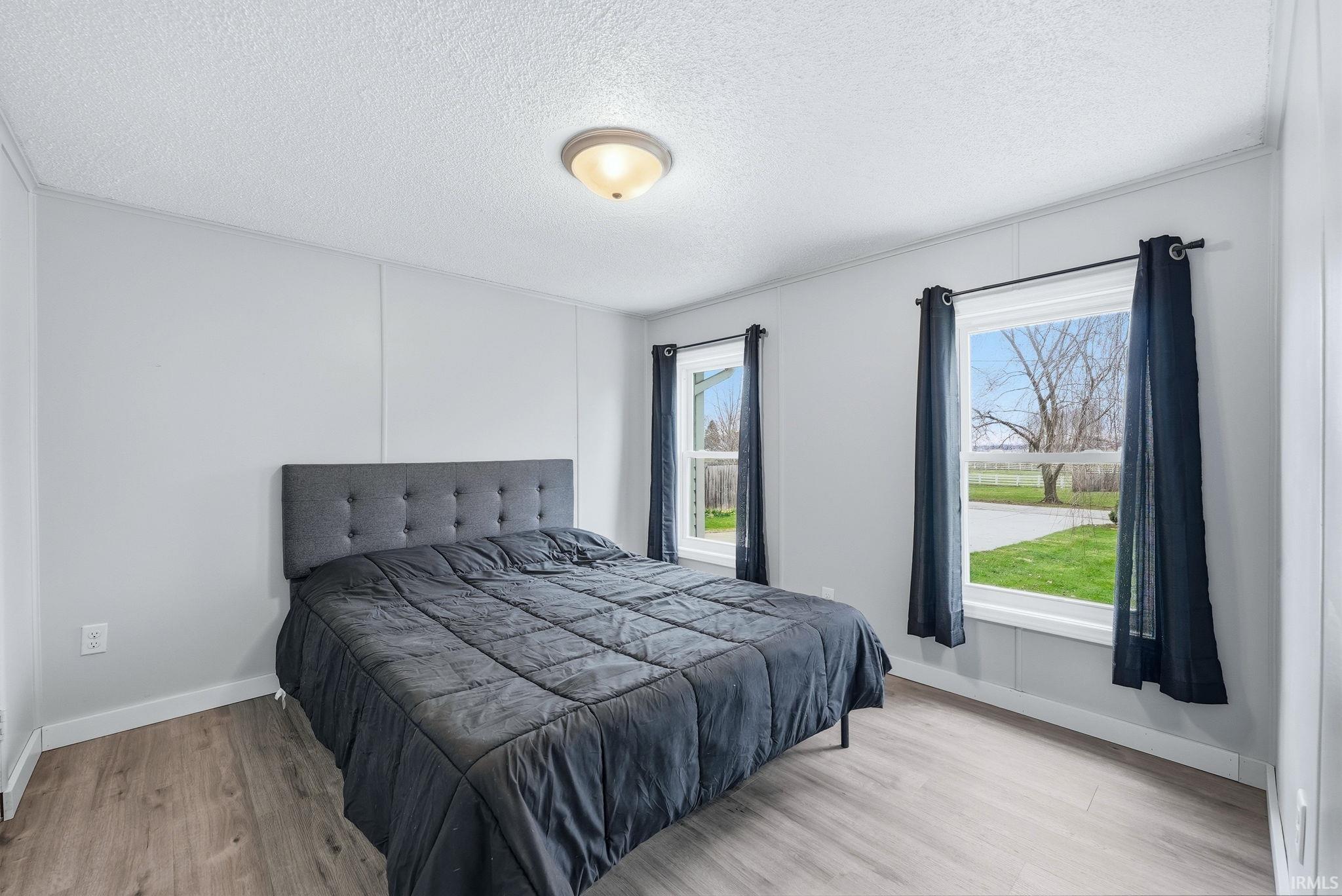 Bedroom featuring light wood-style floors and a textured ceiling