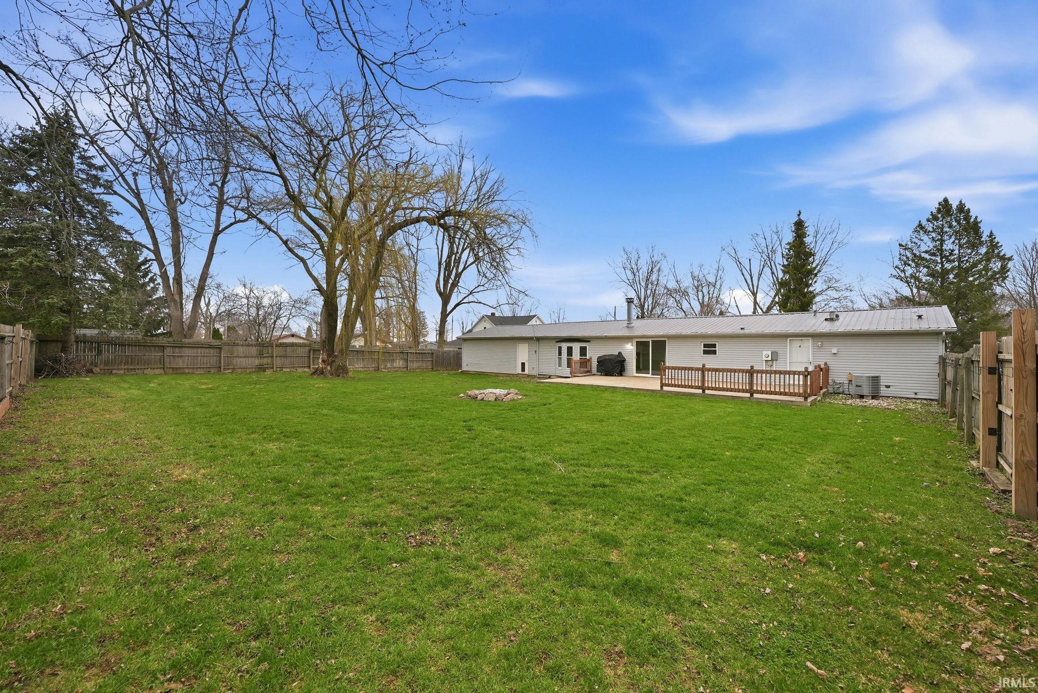 Back of house with a fenced backyard and a patio