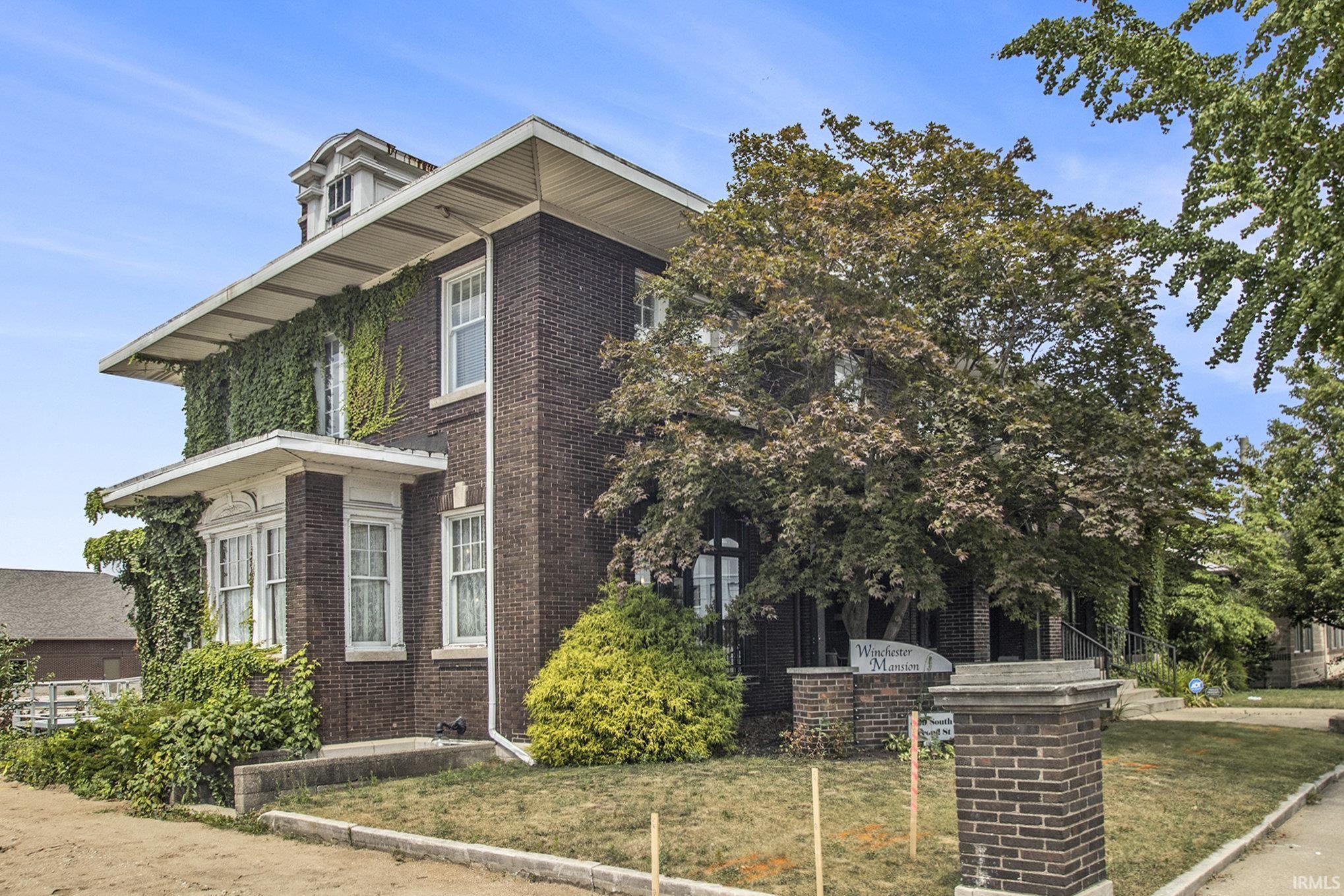 View of front facade with a front lawn and brick siding