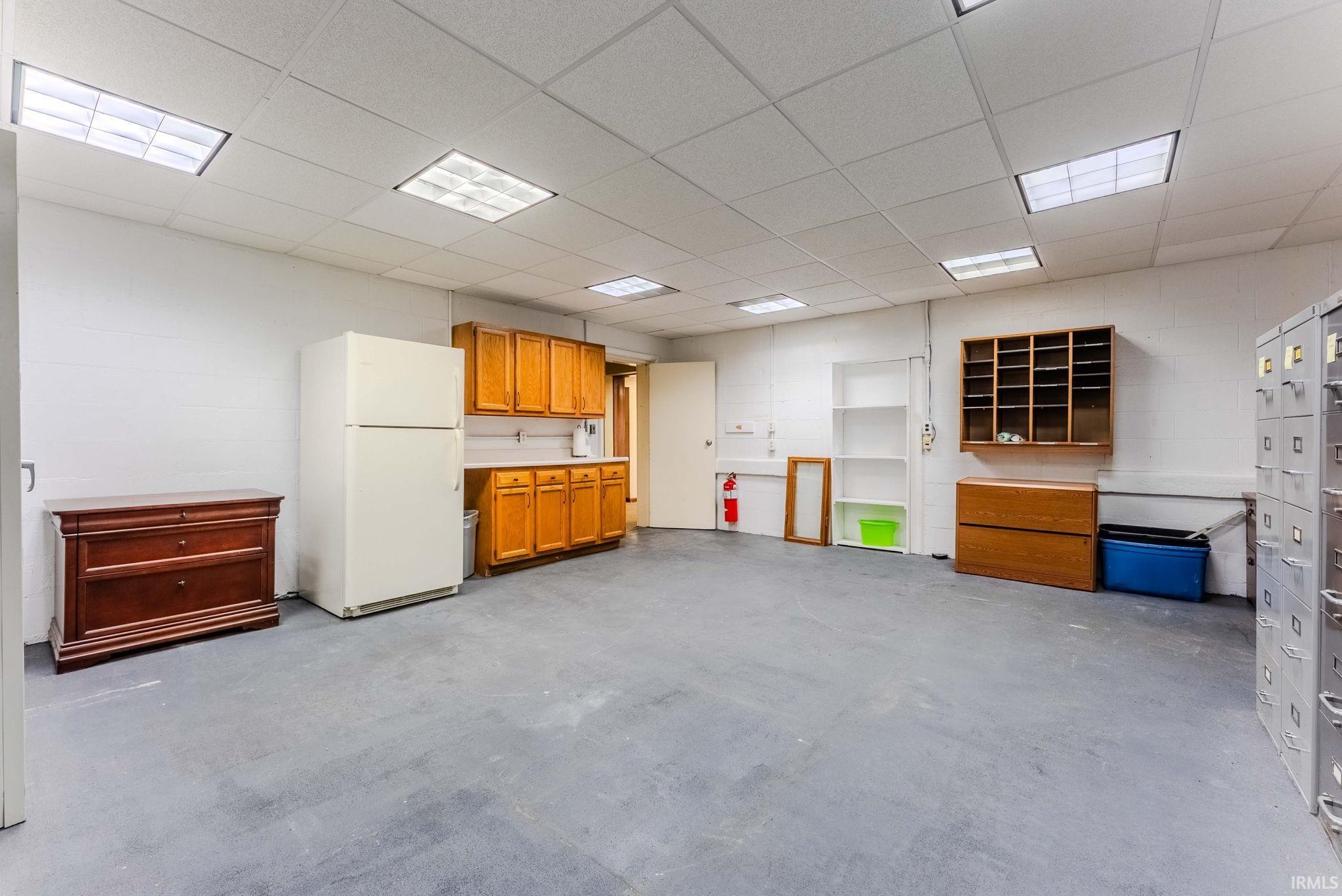 Miscellaneous room featuring concrete flooring and a drop ceiling