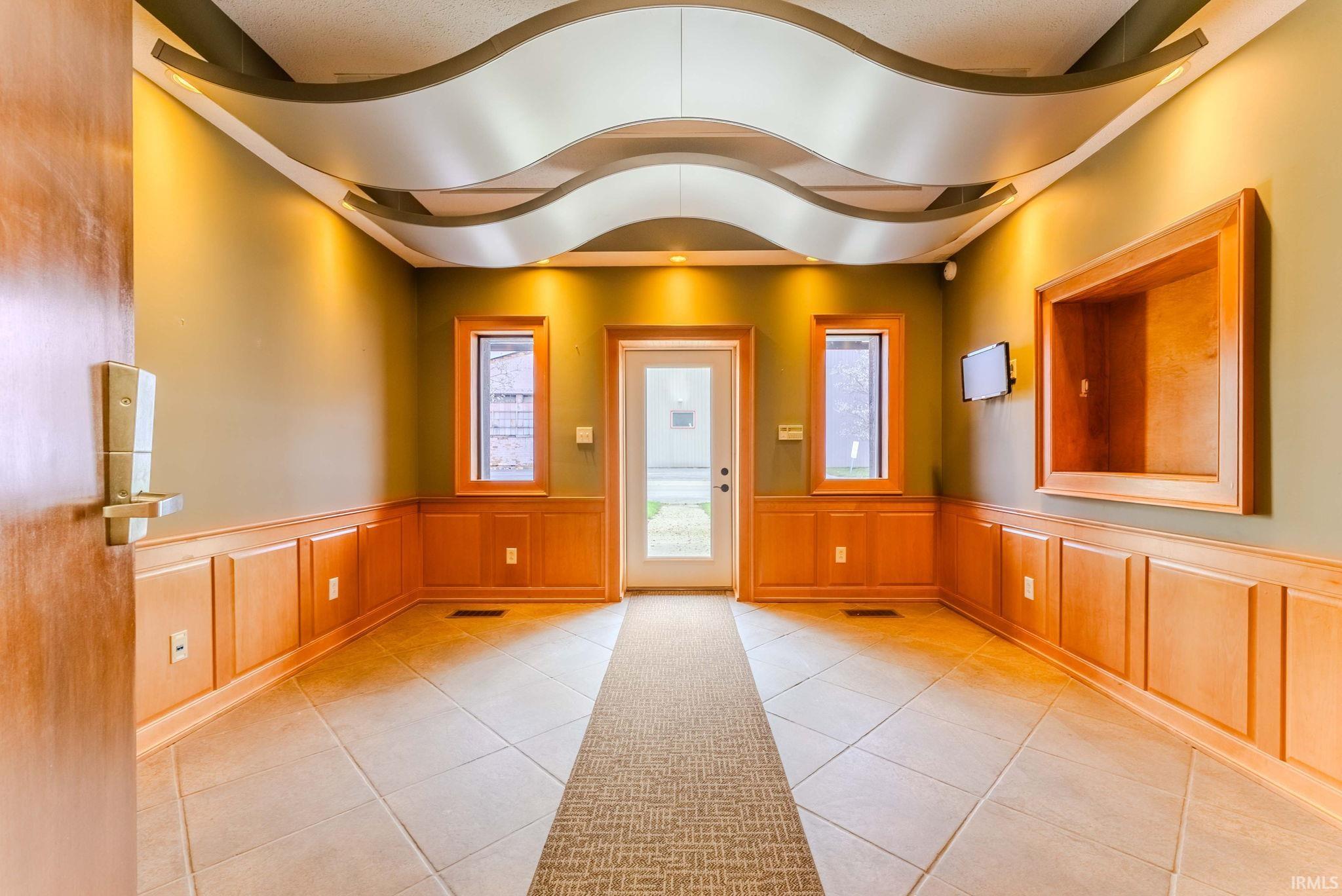 Entrance foyer with wainscoting and a decorative wall