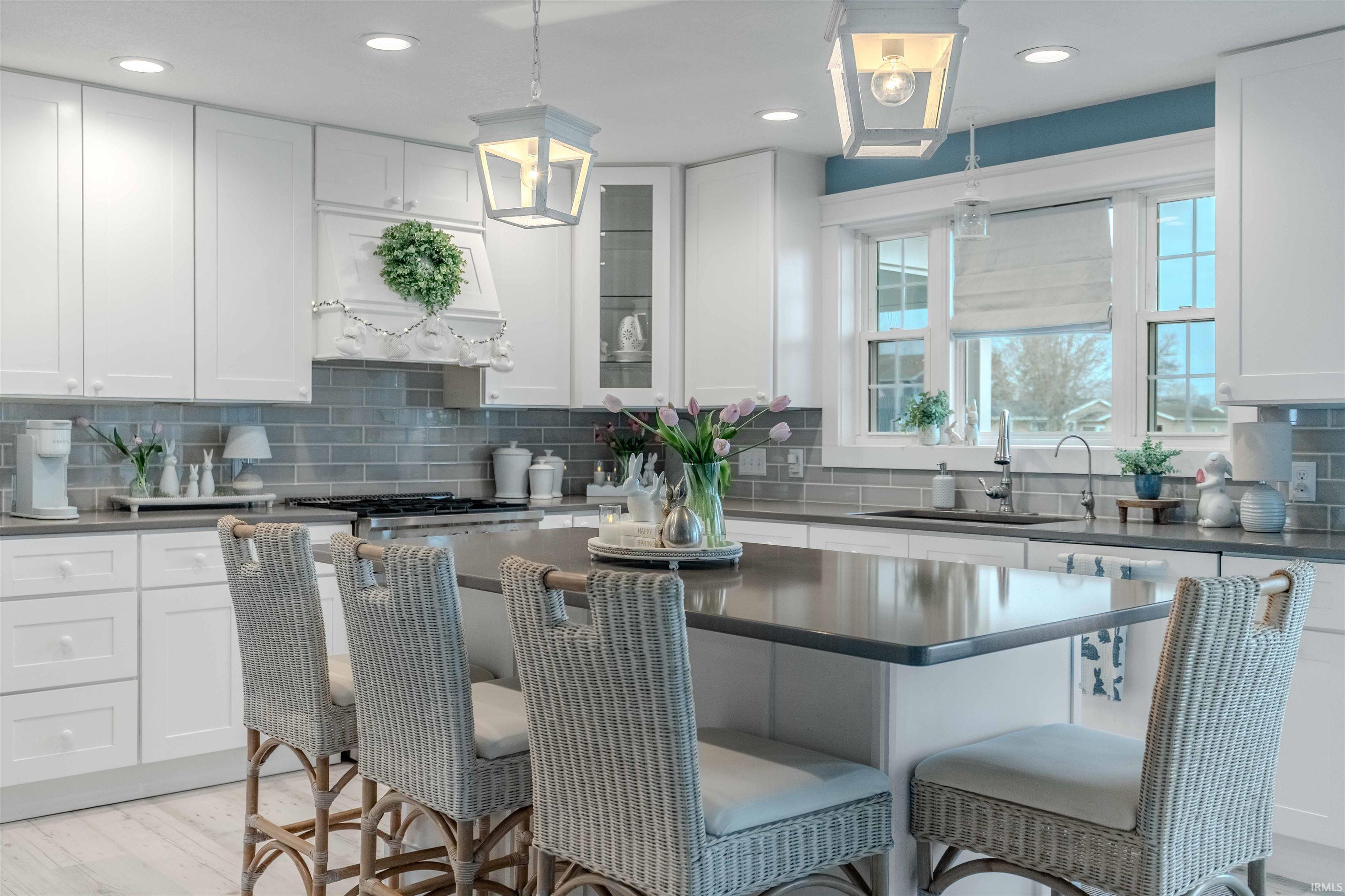 Kitchen with a breakfast bar, white cabinets, and a kitchen island
