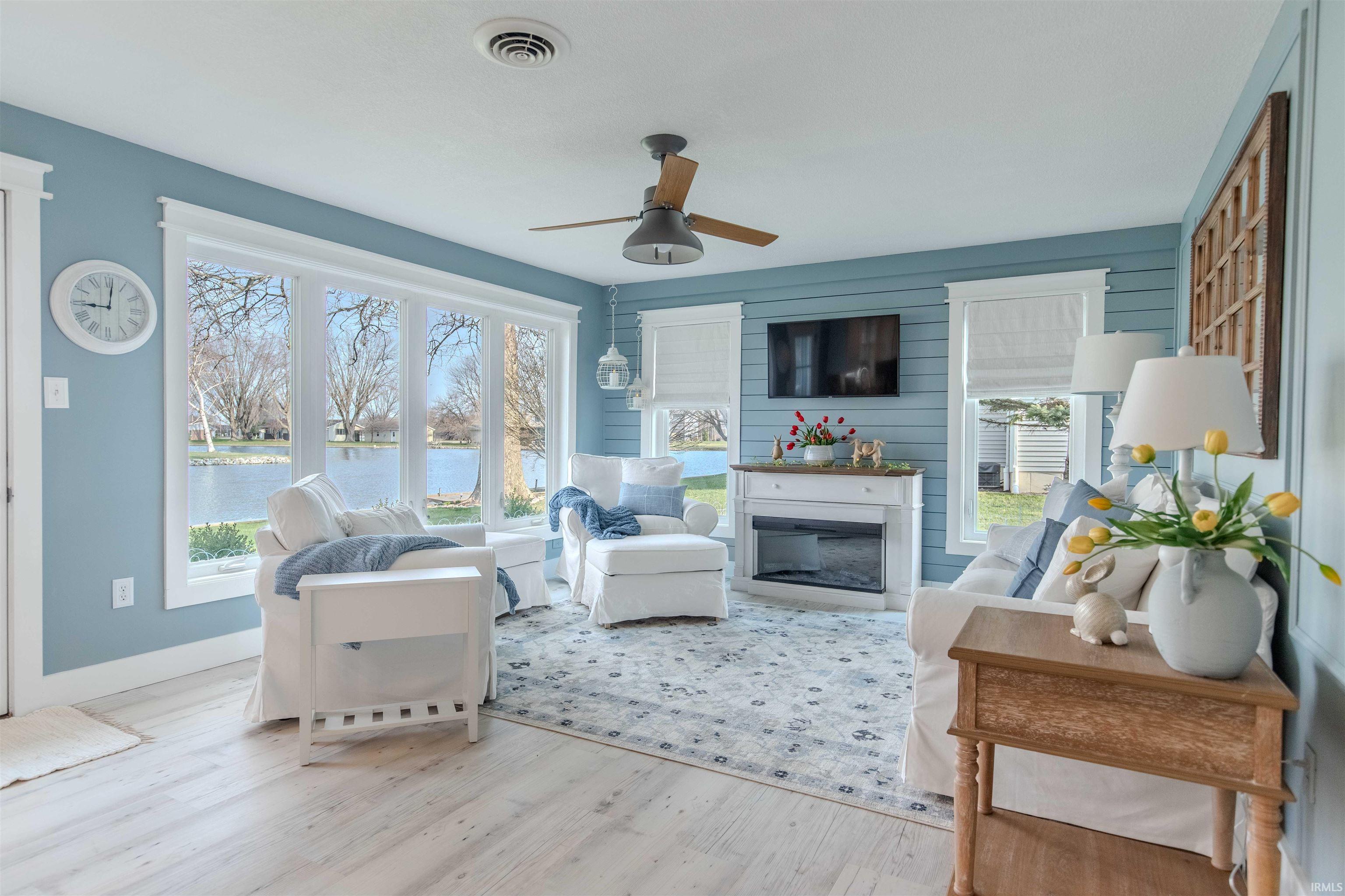 Living room featuring ceiling fan, wood finished floors, and healthy amount of natural light