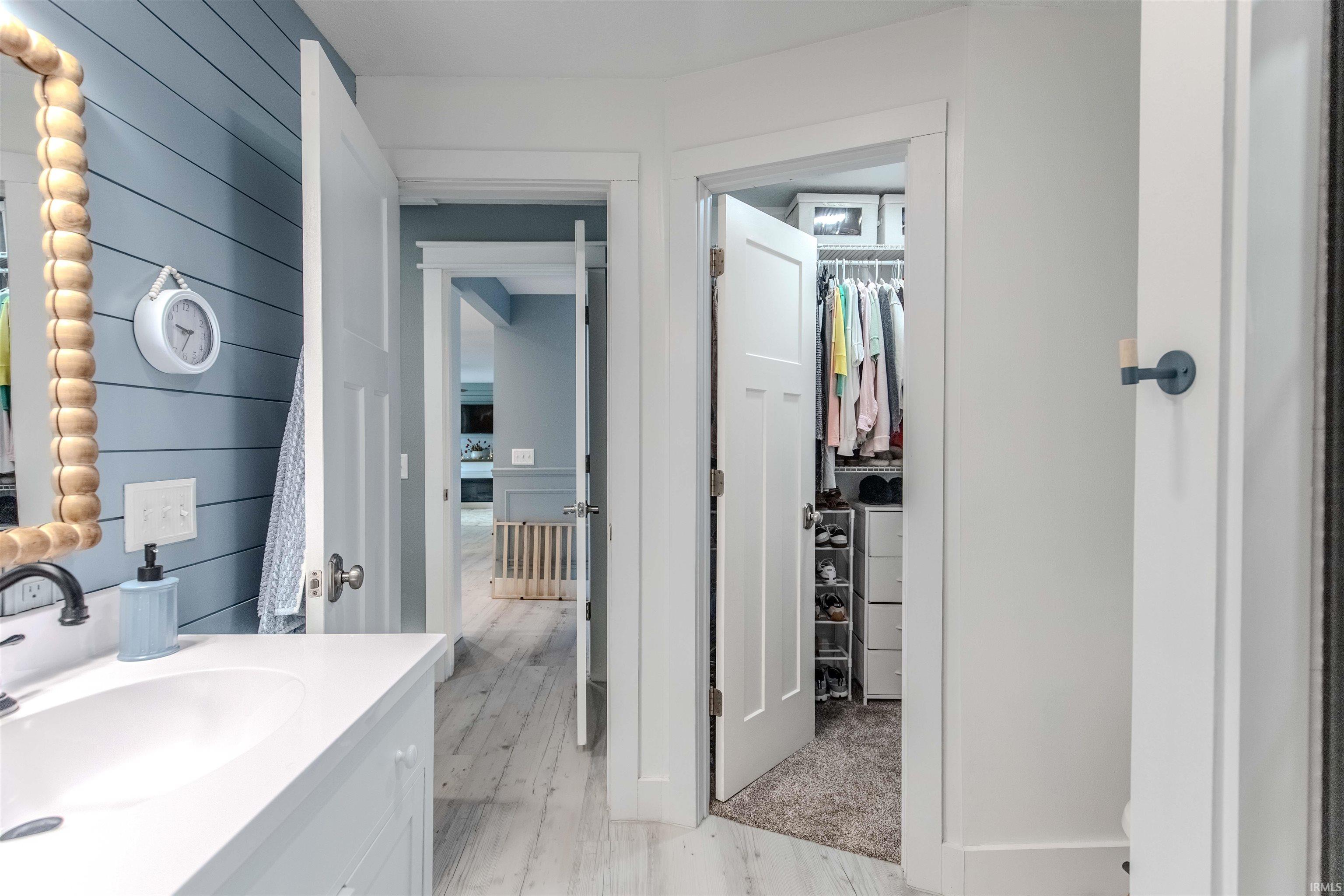 Bathroom featuring vanity, light wood-style floors, and a walk in closet
