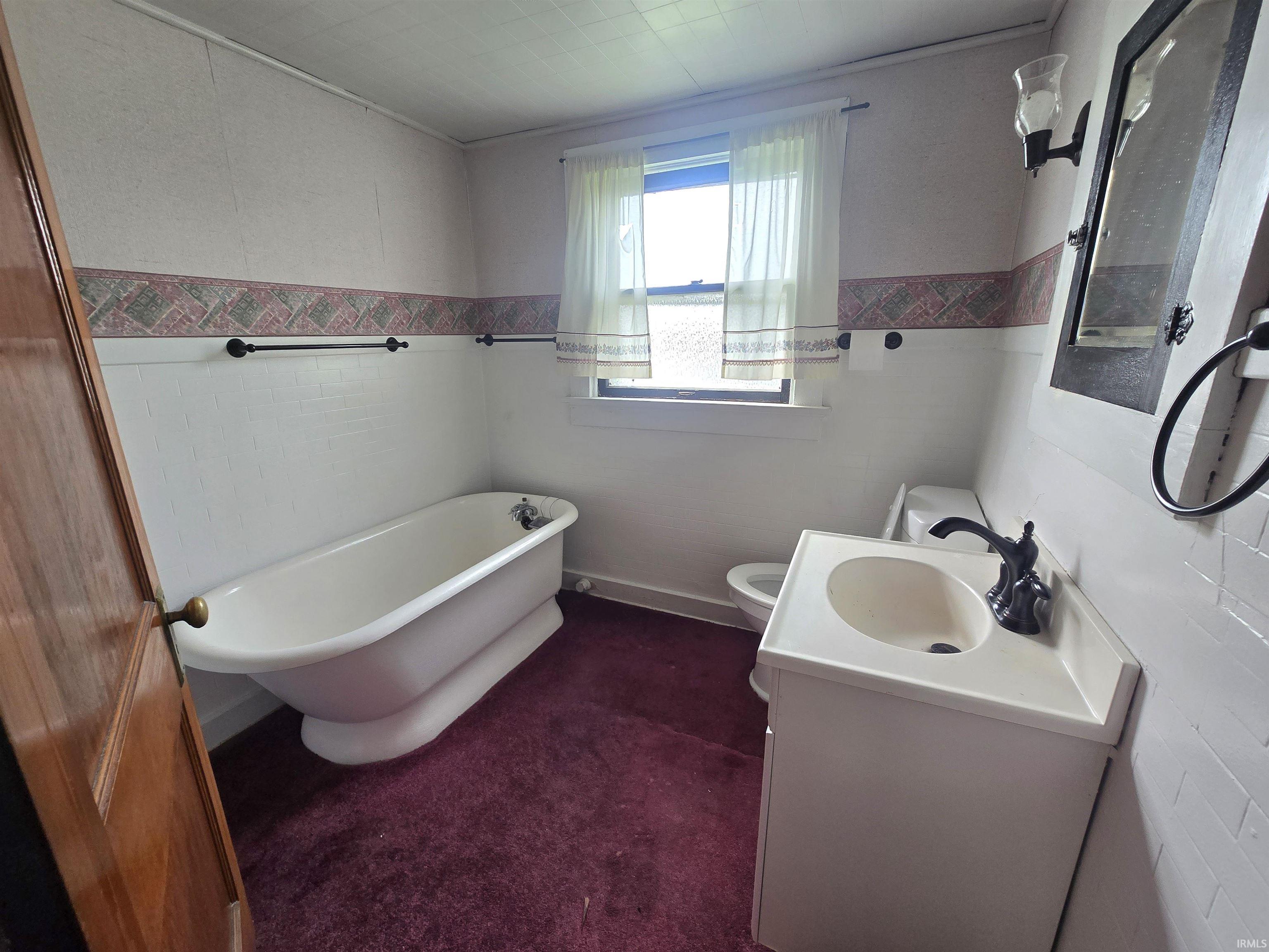 Full bathroom with a soaking tub and vanity