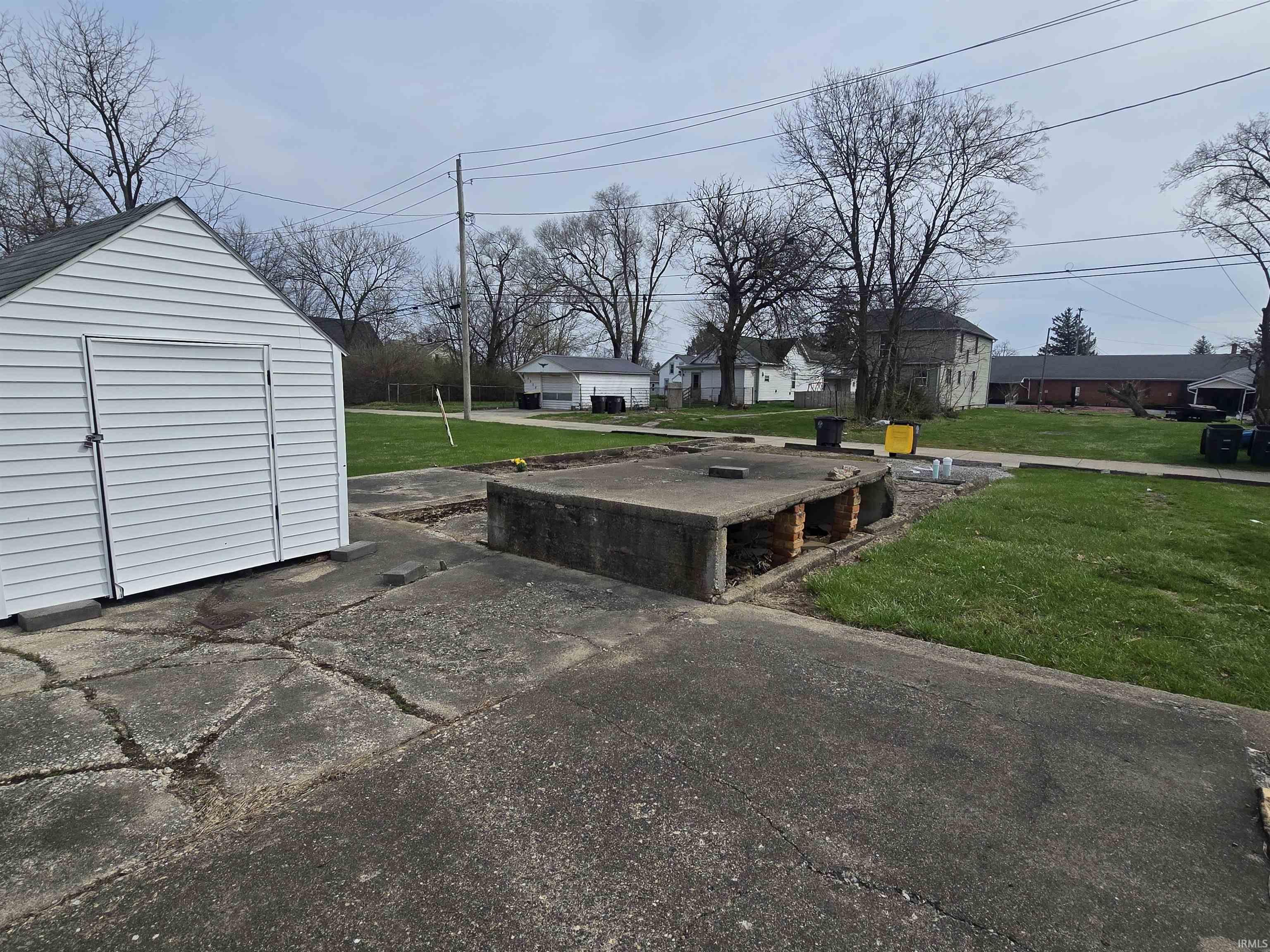 View of green lawn featuring a shed and a residential view