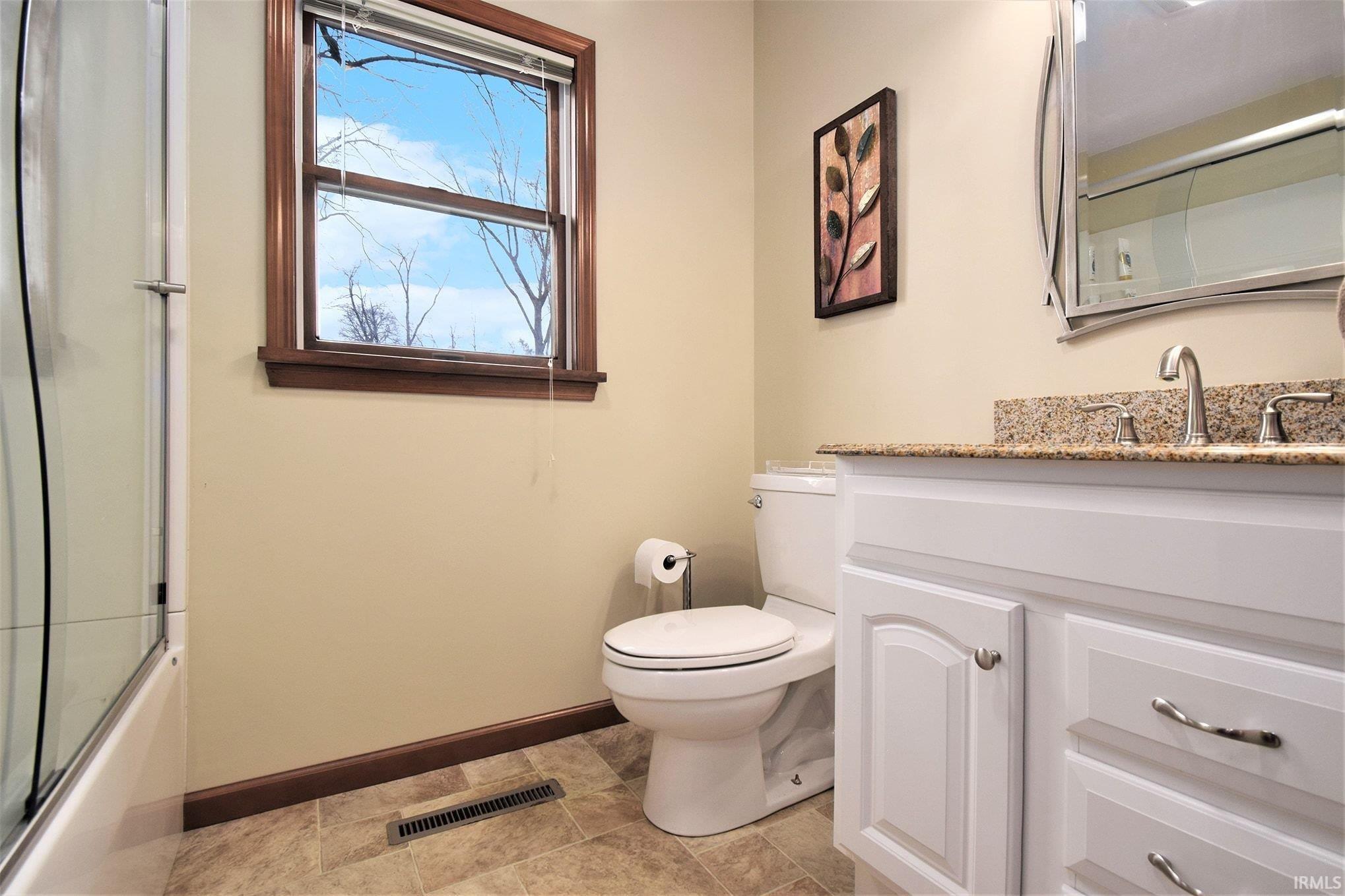 Full bath with vanity and bath / shower combo with glass door