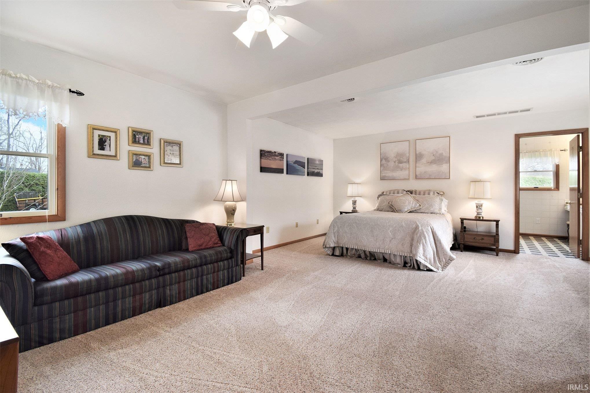 Carpeted bedroom featuring baseboards and ceiling fan
