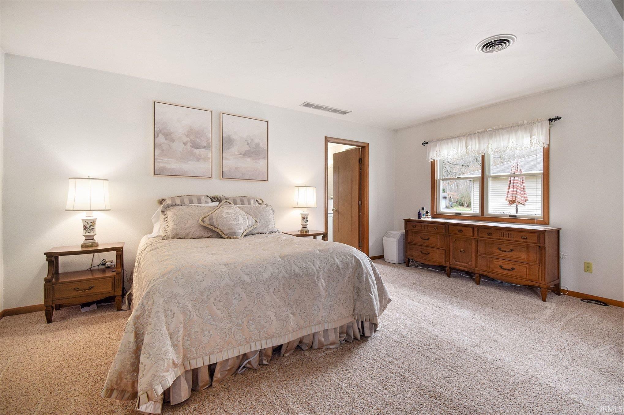 Bedroom featuring light colored carpet and baseboards