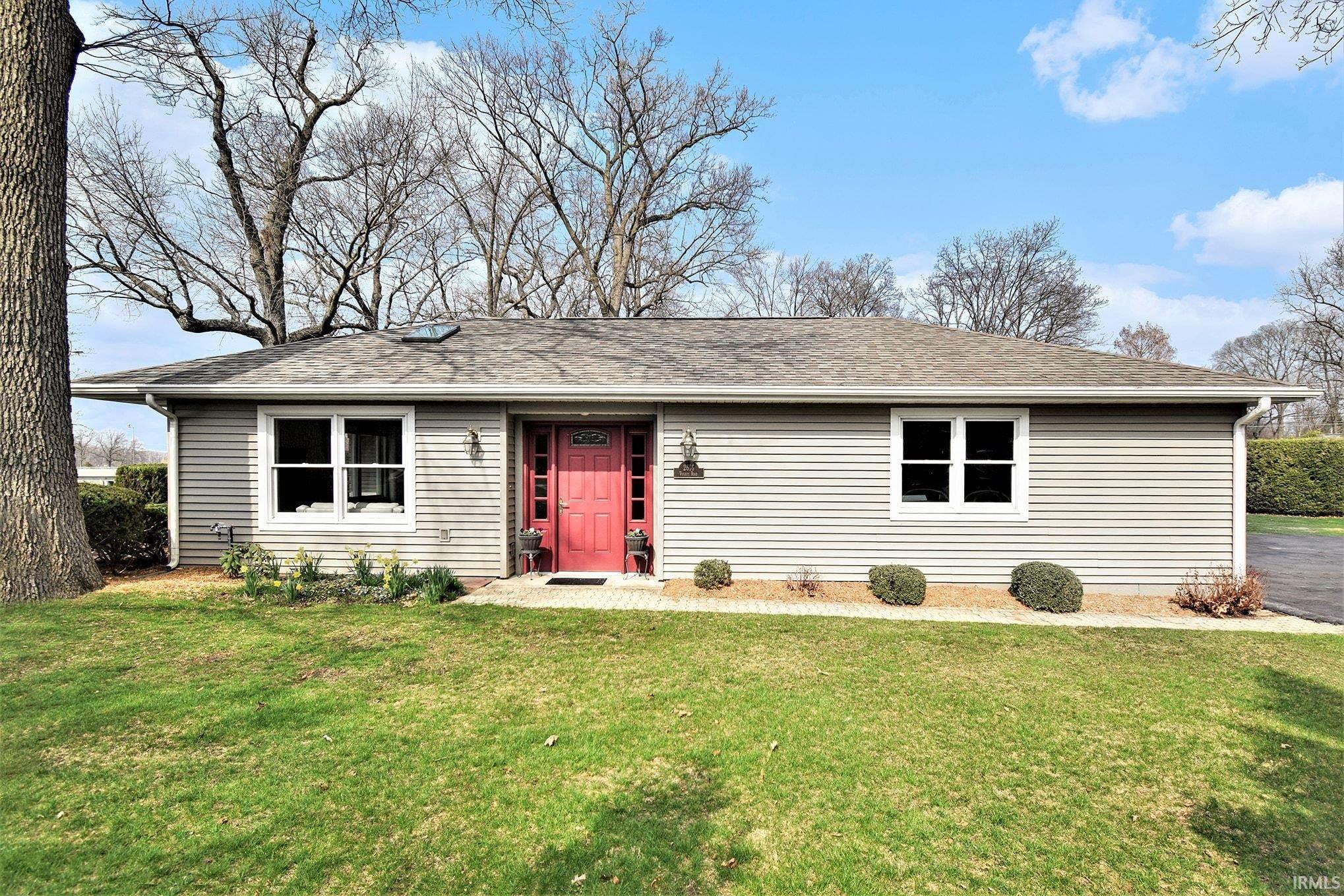Single story home featuring roof with shingles and a front lawn