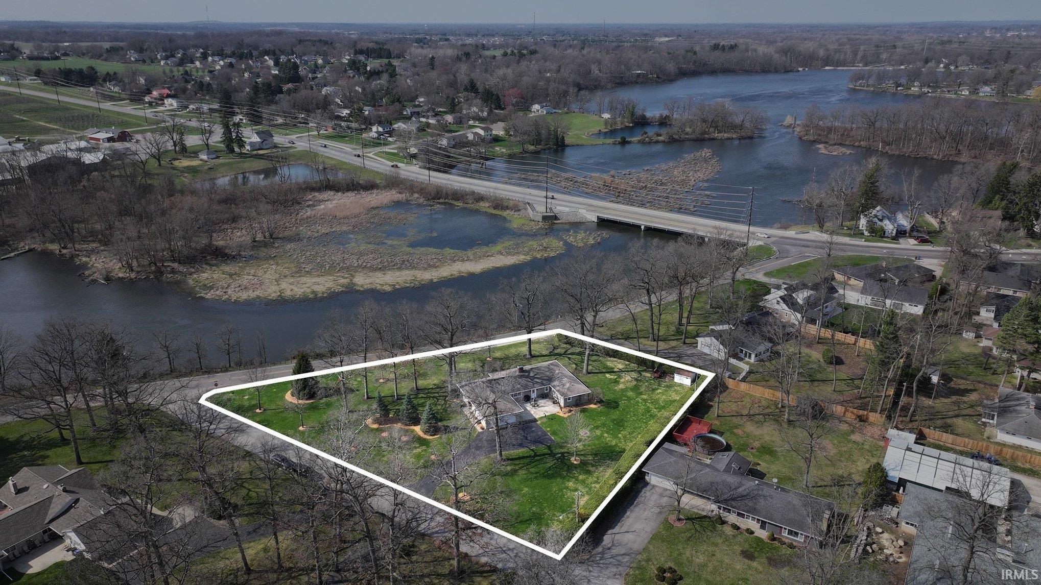 Aerial view of residential area featuring a large body of water and property boundaries highlighted