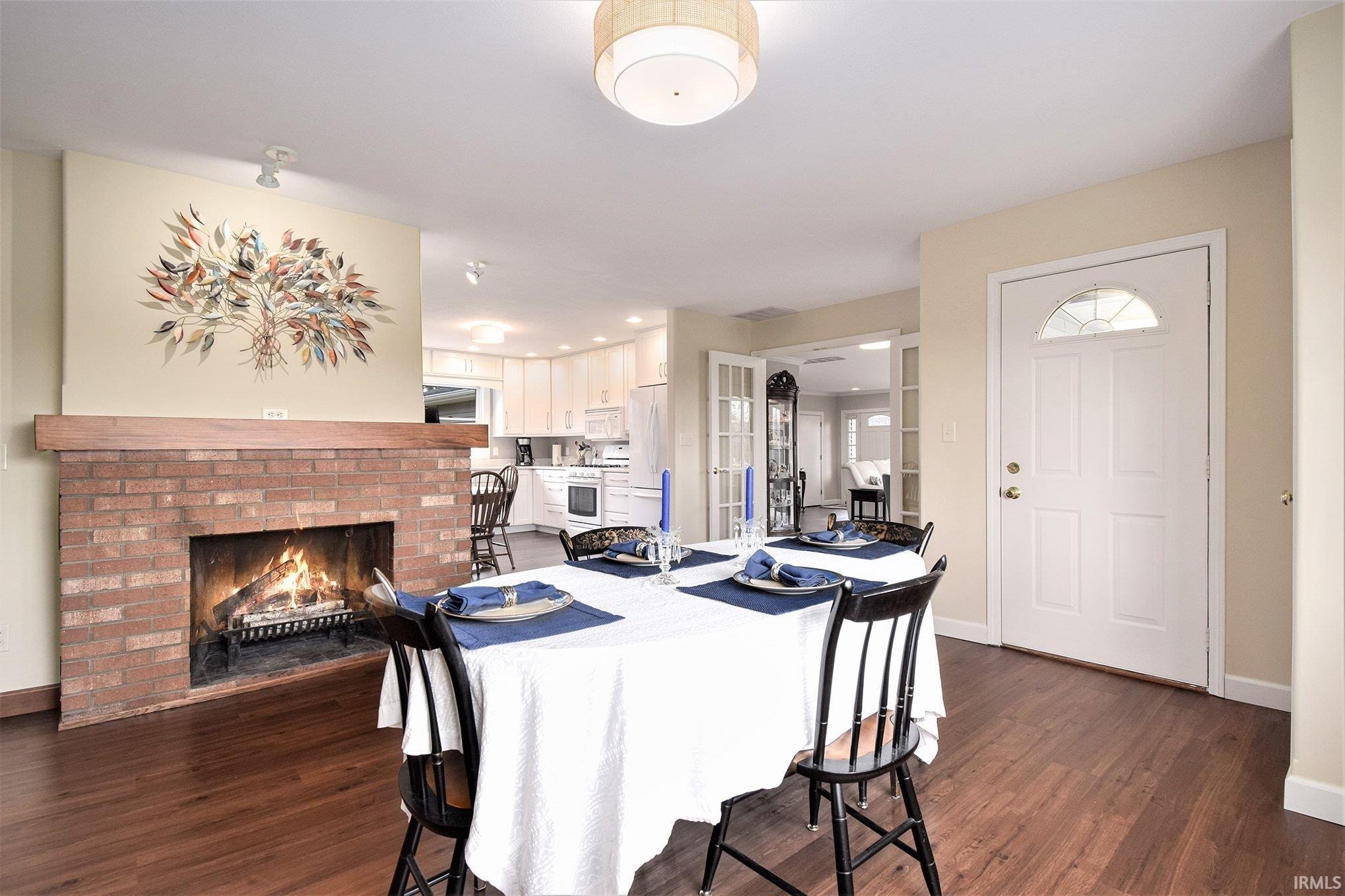 Dining room with a fireplace and dark wood-style flooring