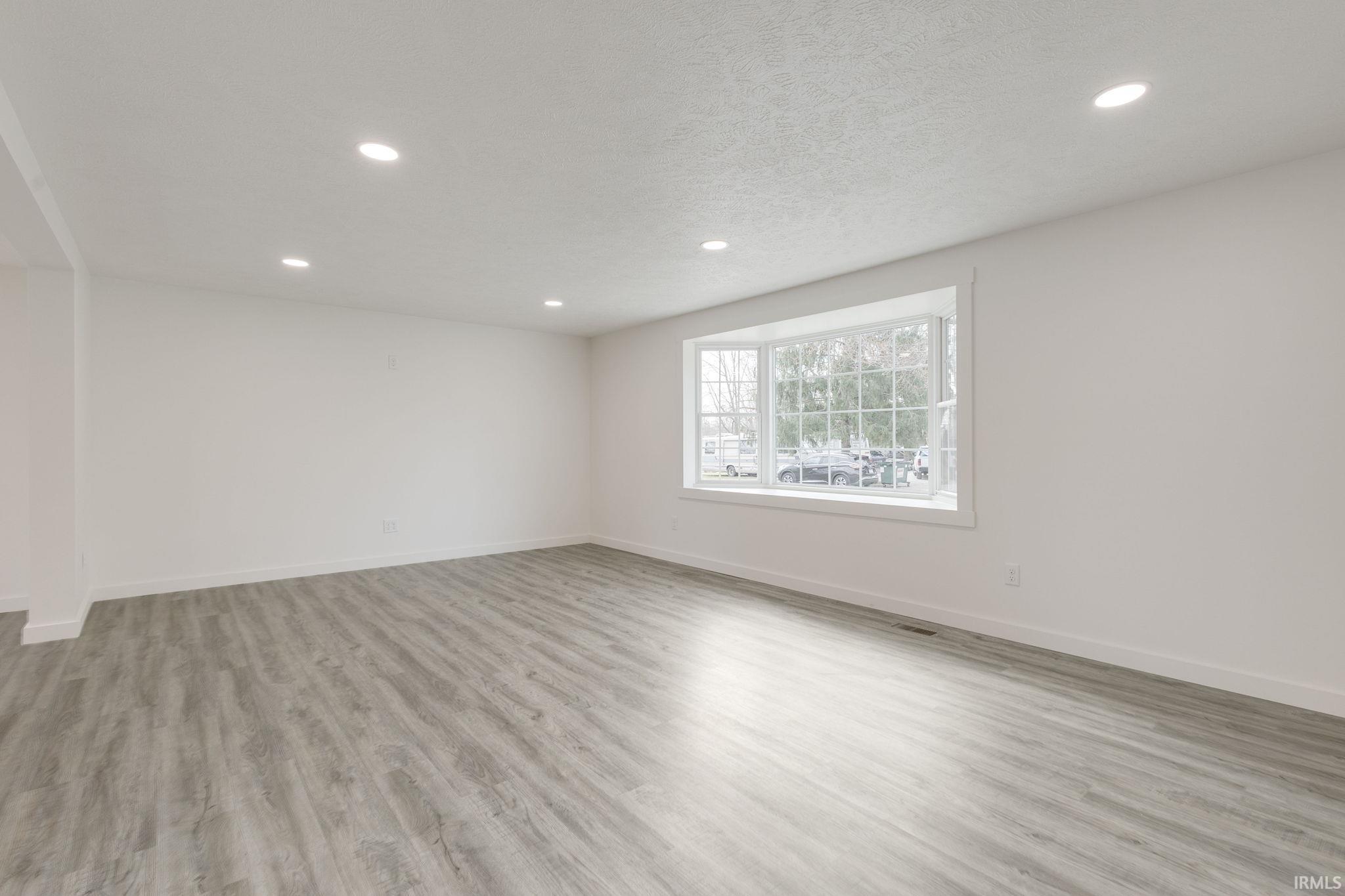 Living Room featuring light wood-style floors, recessed lighting, and a textured ceiling