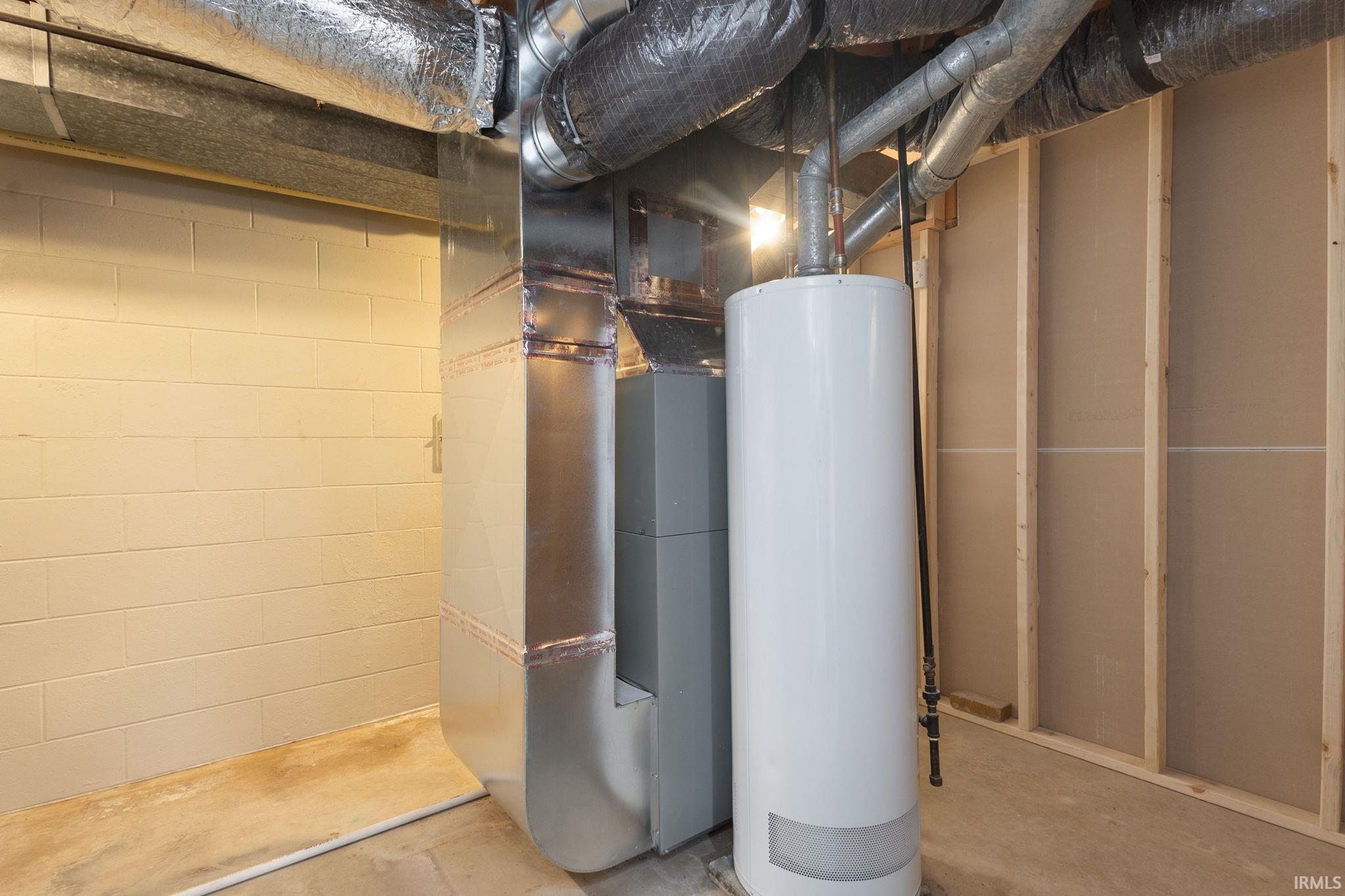 Utility room featuring water heater and heating unit