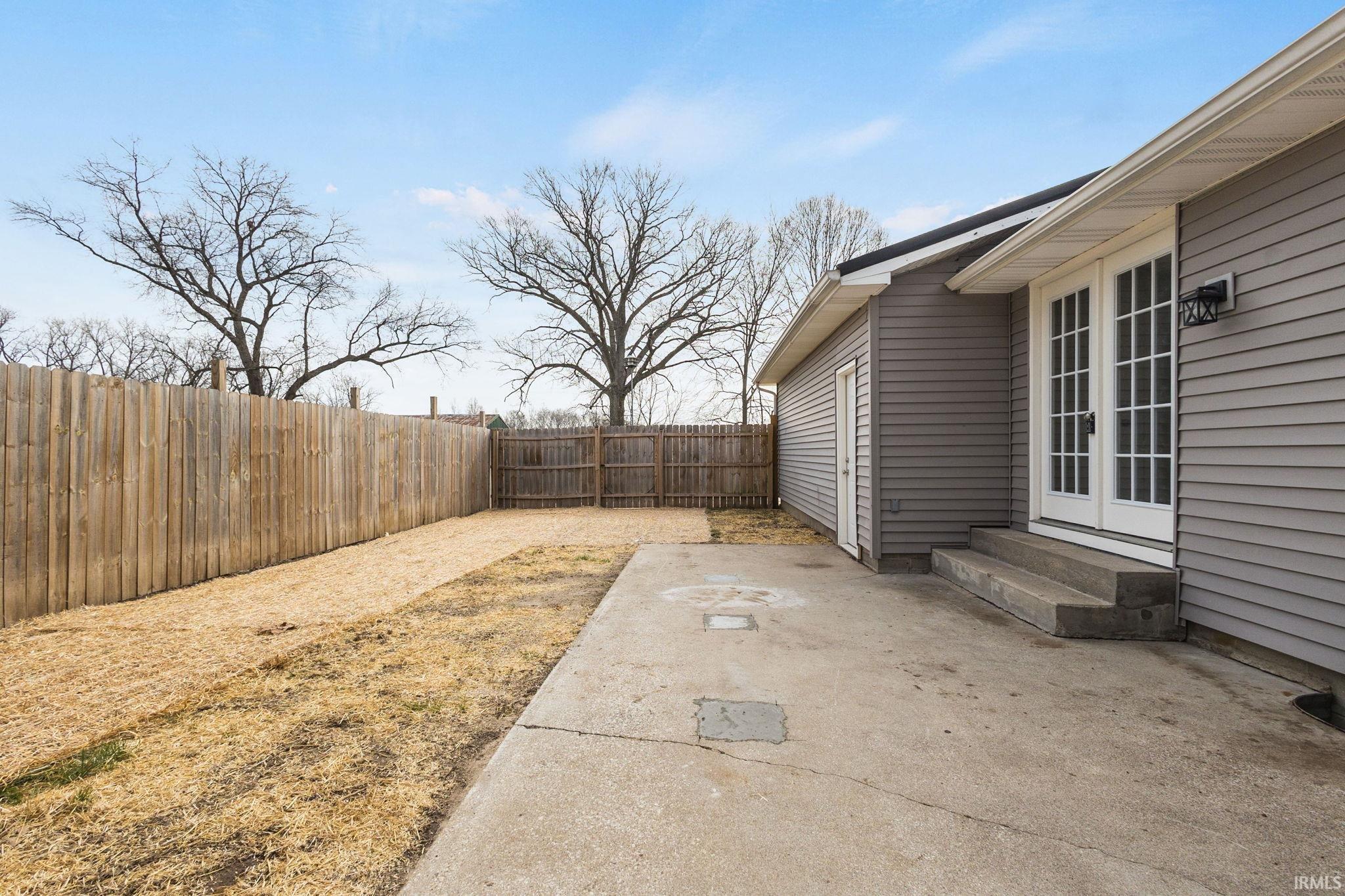 Fenced backyard with a patio area and entry steps