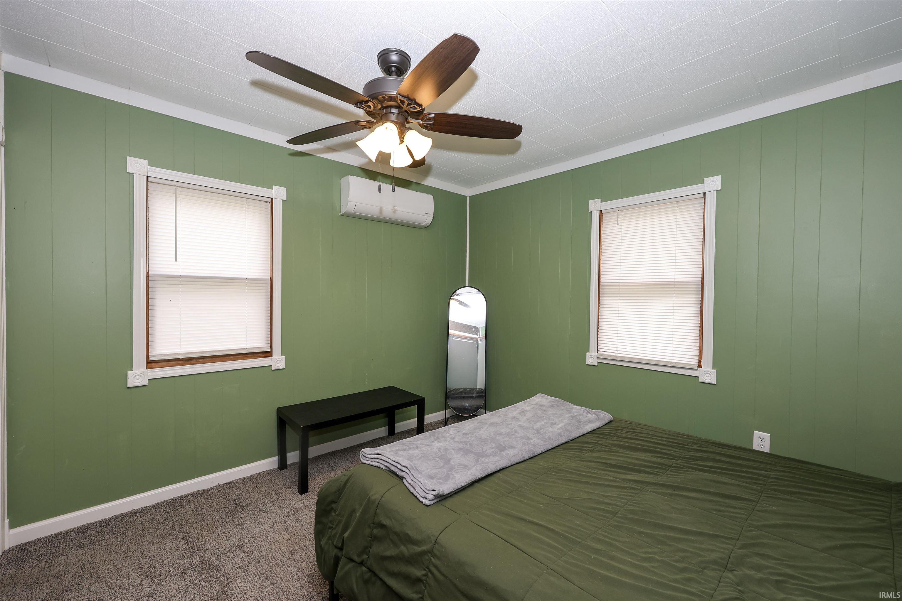 Bedroom with dark carpet, a ceiling fan, and crown molding