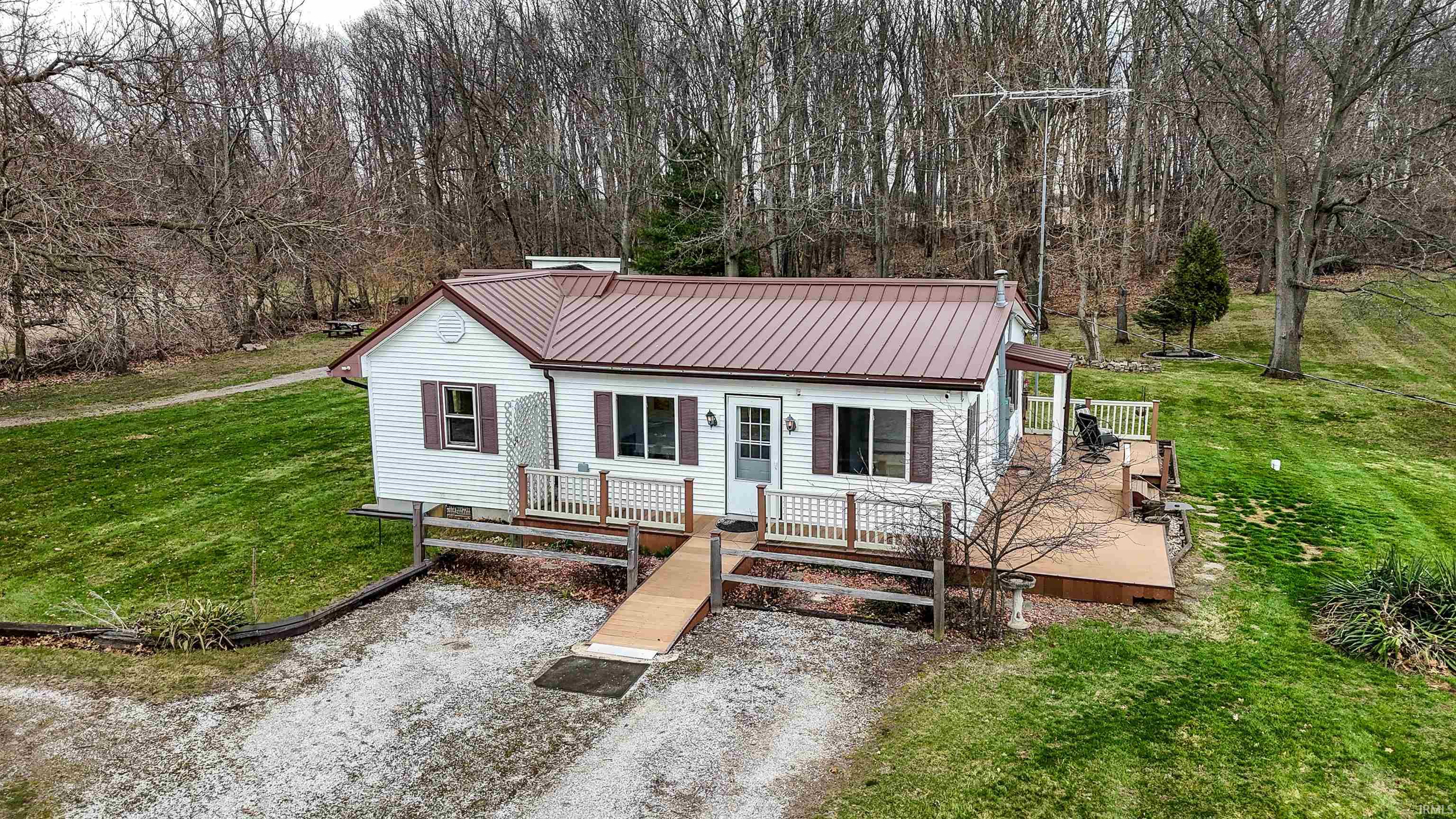 View of front facade with a front yard, a metal roof, and a deck