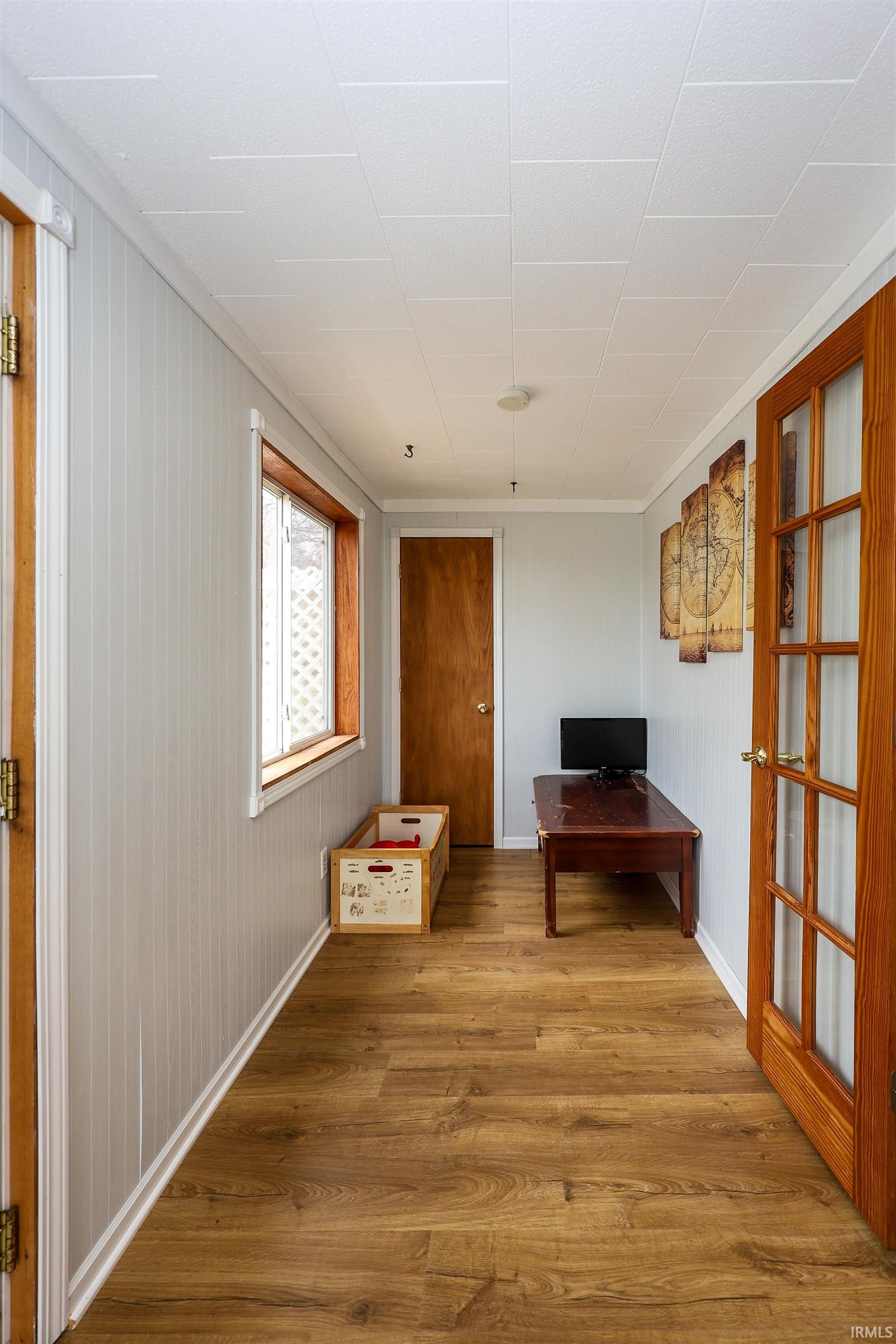 Hallway featuring wood finished floors and baseboards