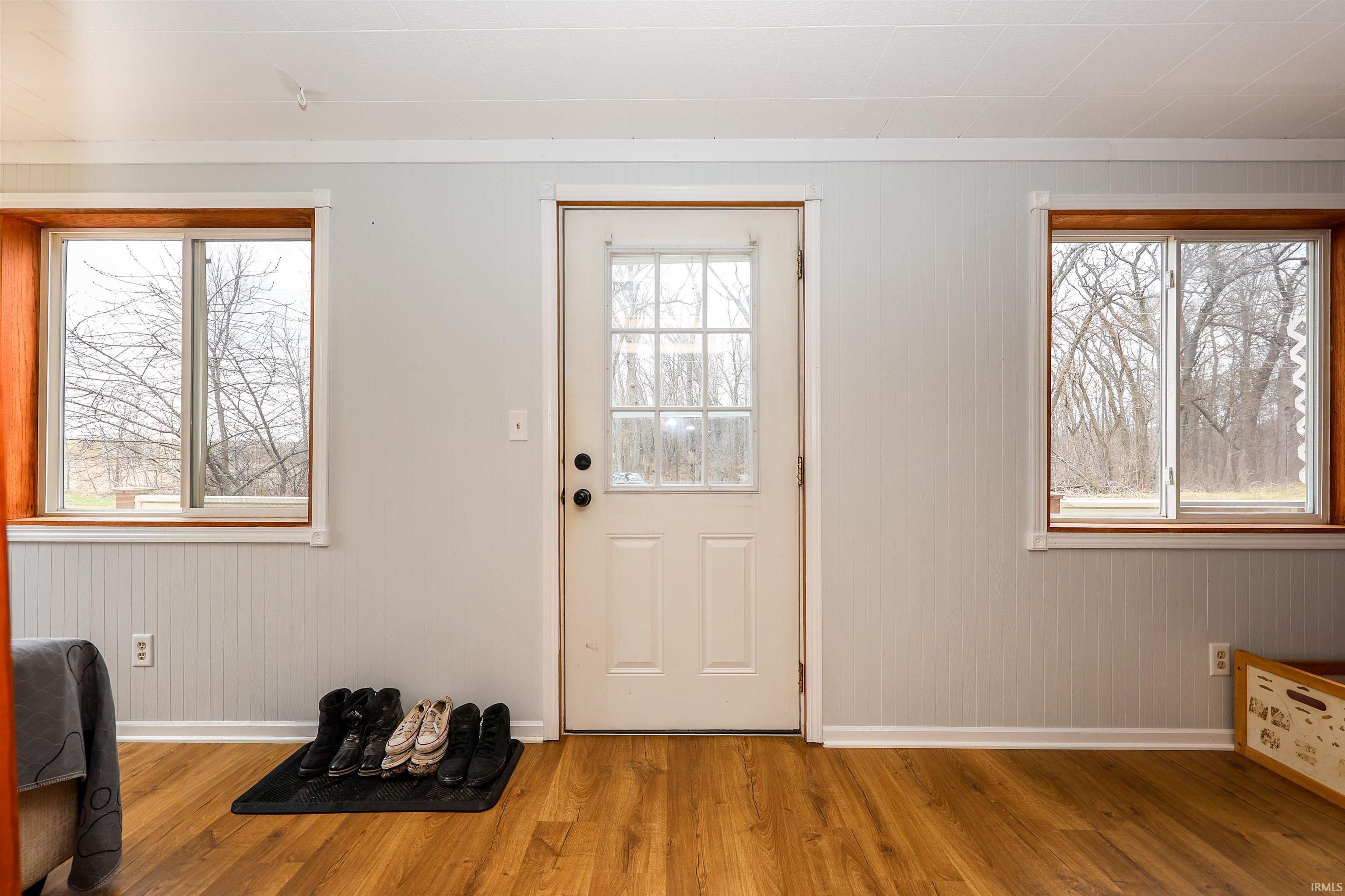 Foyer with wood finished floors and wood walls