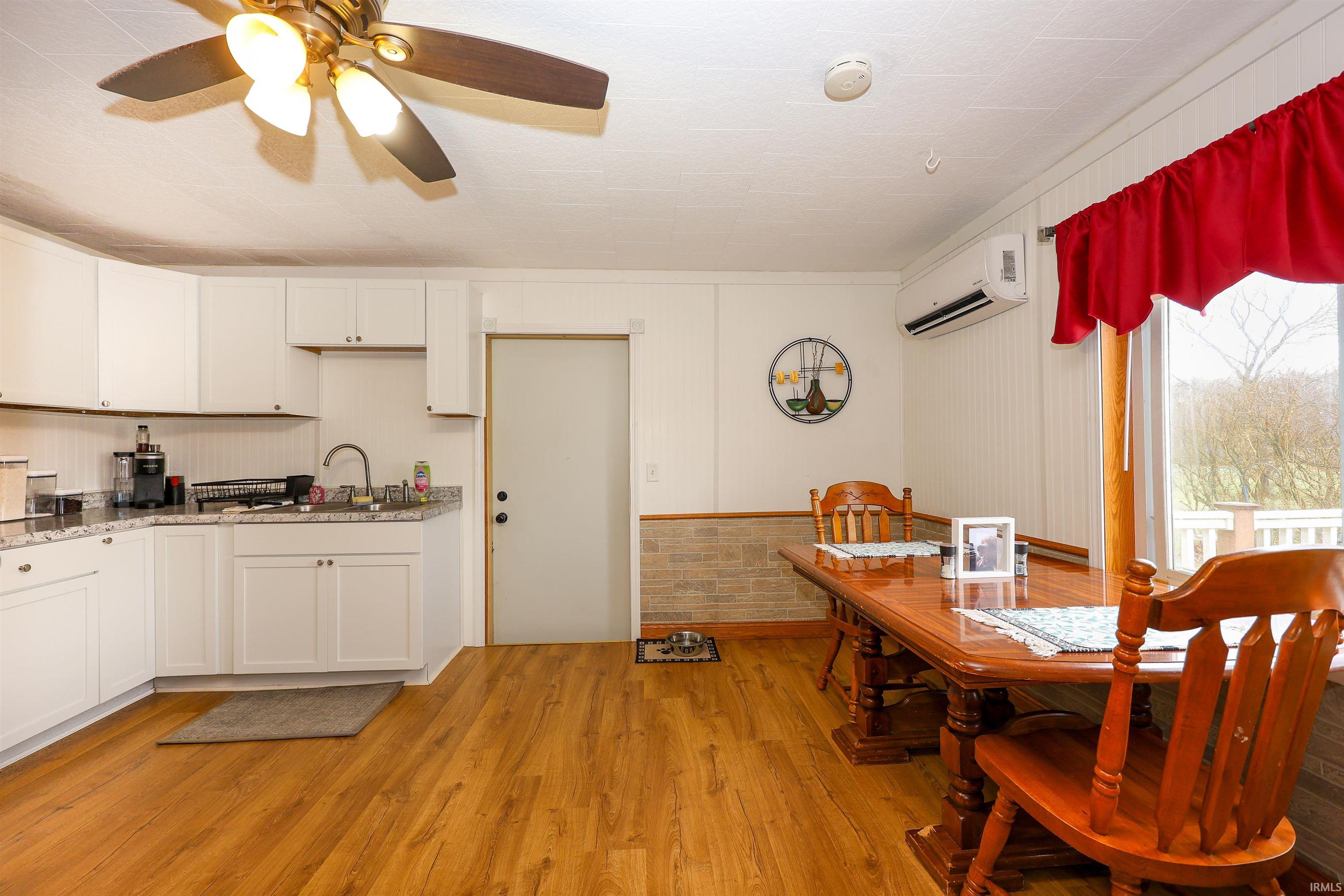 Kitchen with white cabinets, light wood-type flooring, and ceiling fan