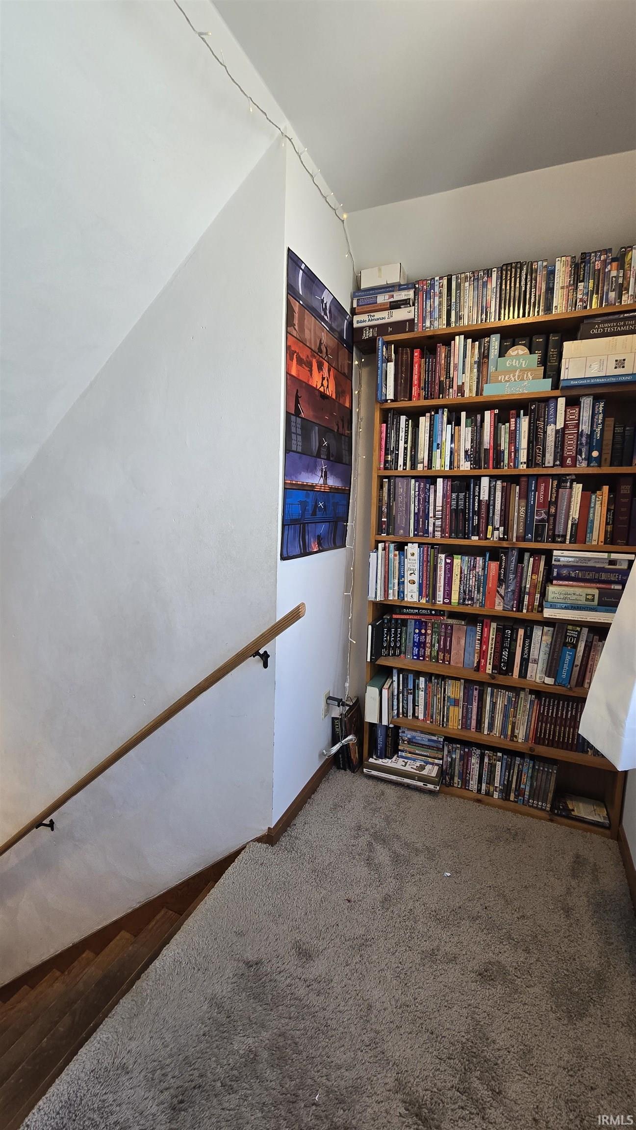 Living area featuring dark carpet and baseboards
