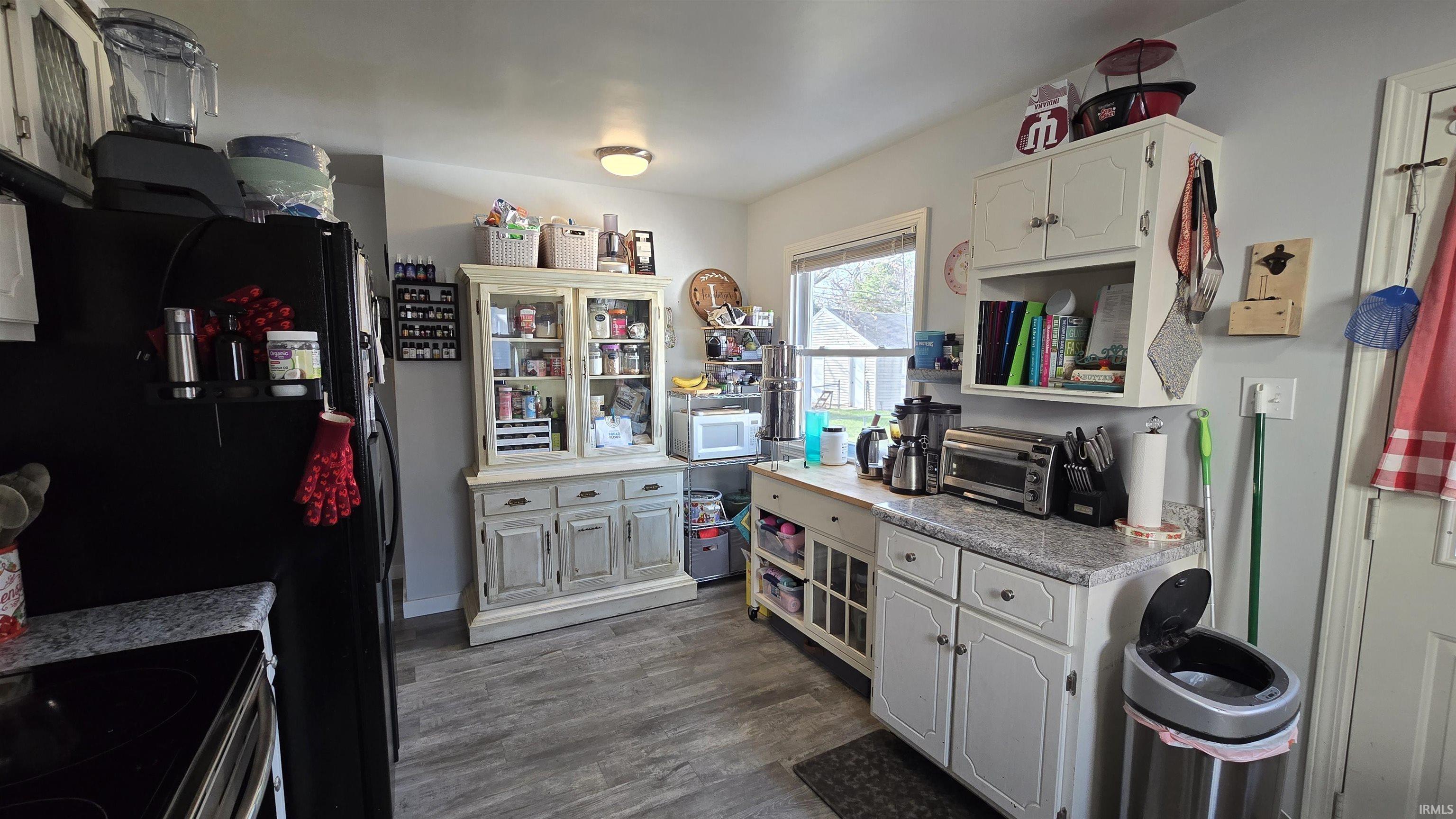 Kitchen with white cabinets, dark wood-style flooring, light countertops, and stainless steel electric stove