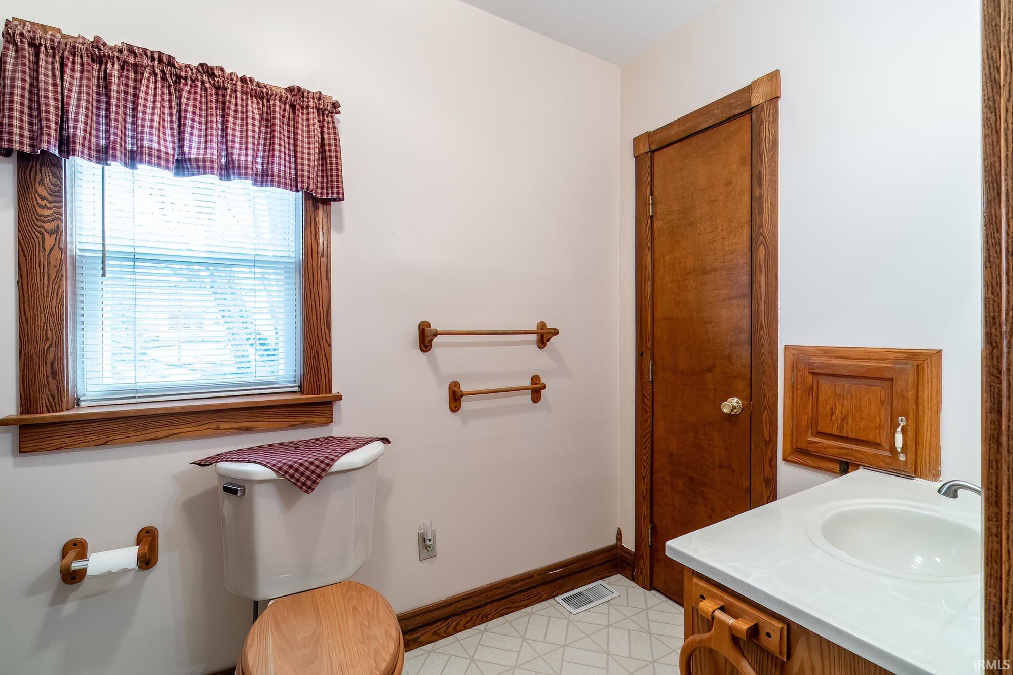 Full bath with vanity and light floors