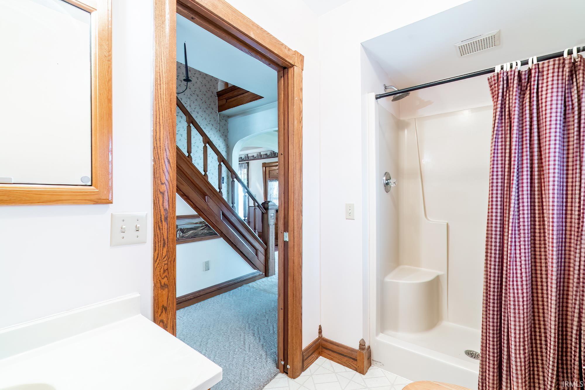Full bathroom with a shower stall, light carpet, and vanity