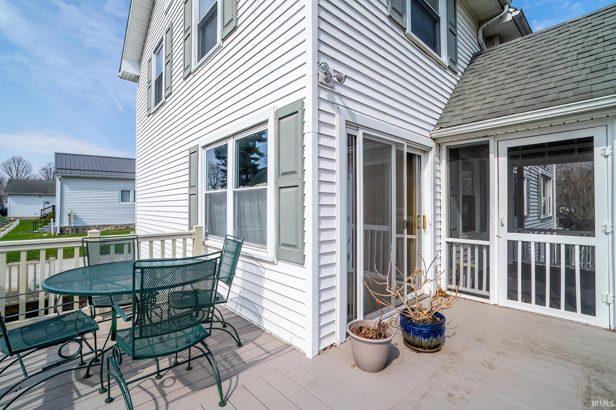 Deck with a sunroom and outdoor dining area