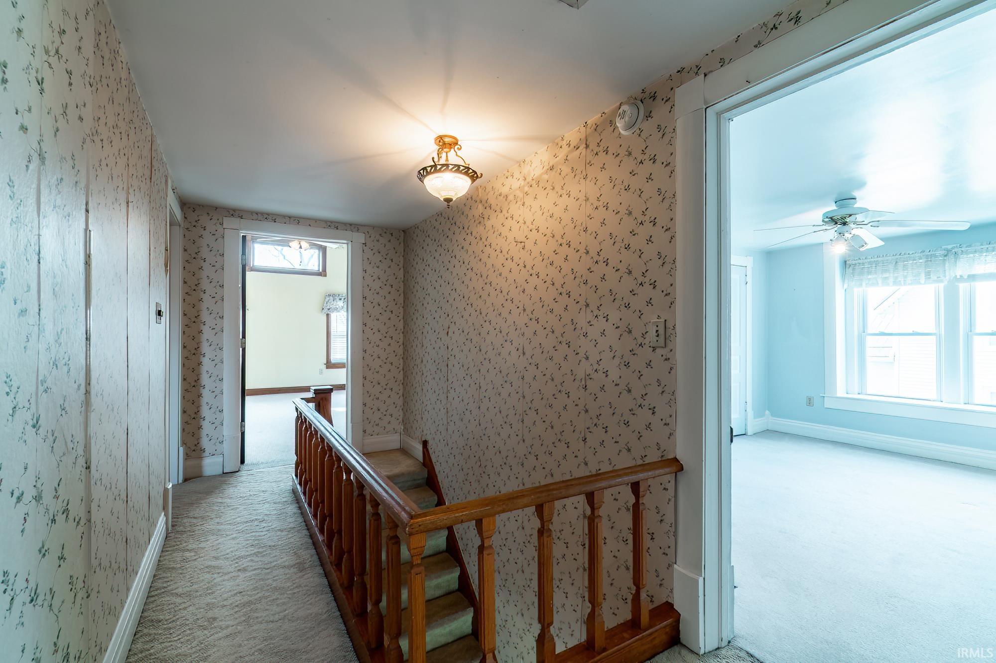 Corridor with carpet flooring and an upstairs landing