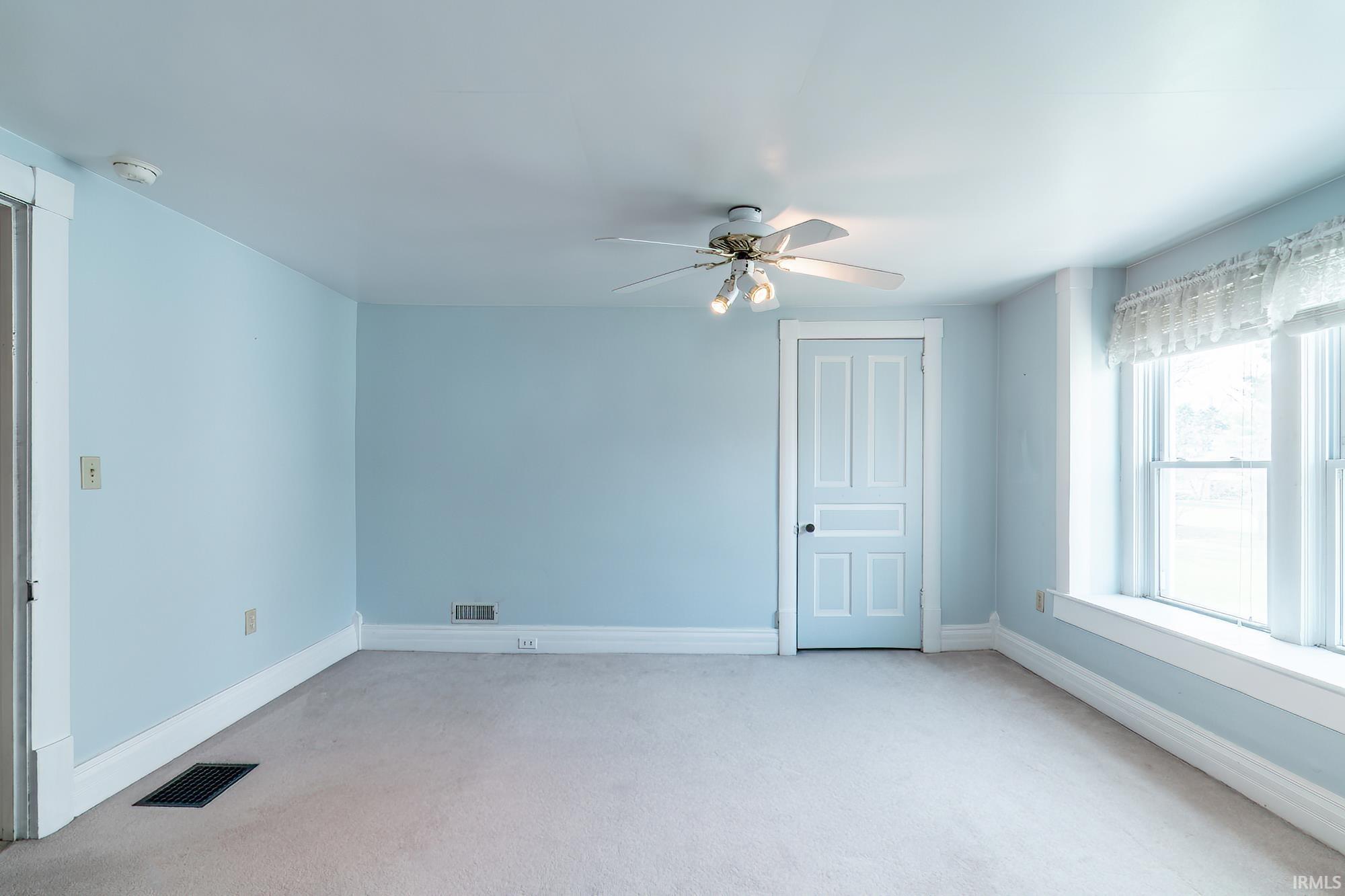Bedroom with a ceiling fan and light carpet
