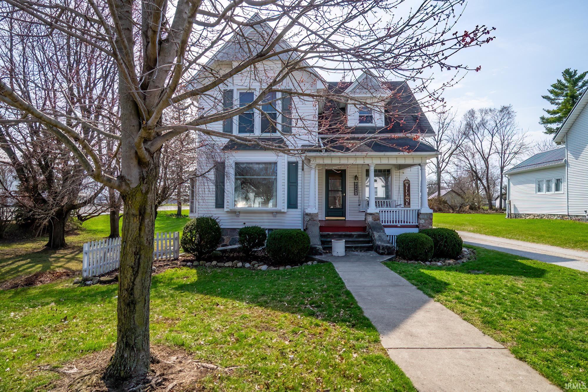 Victorian home featuring a front yard and covered porch
