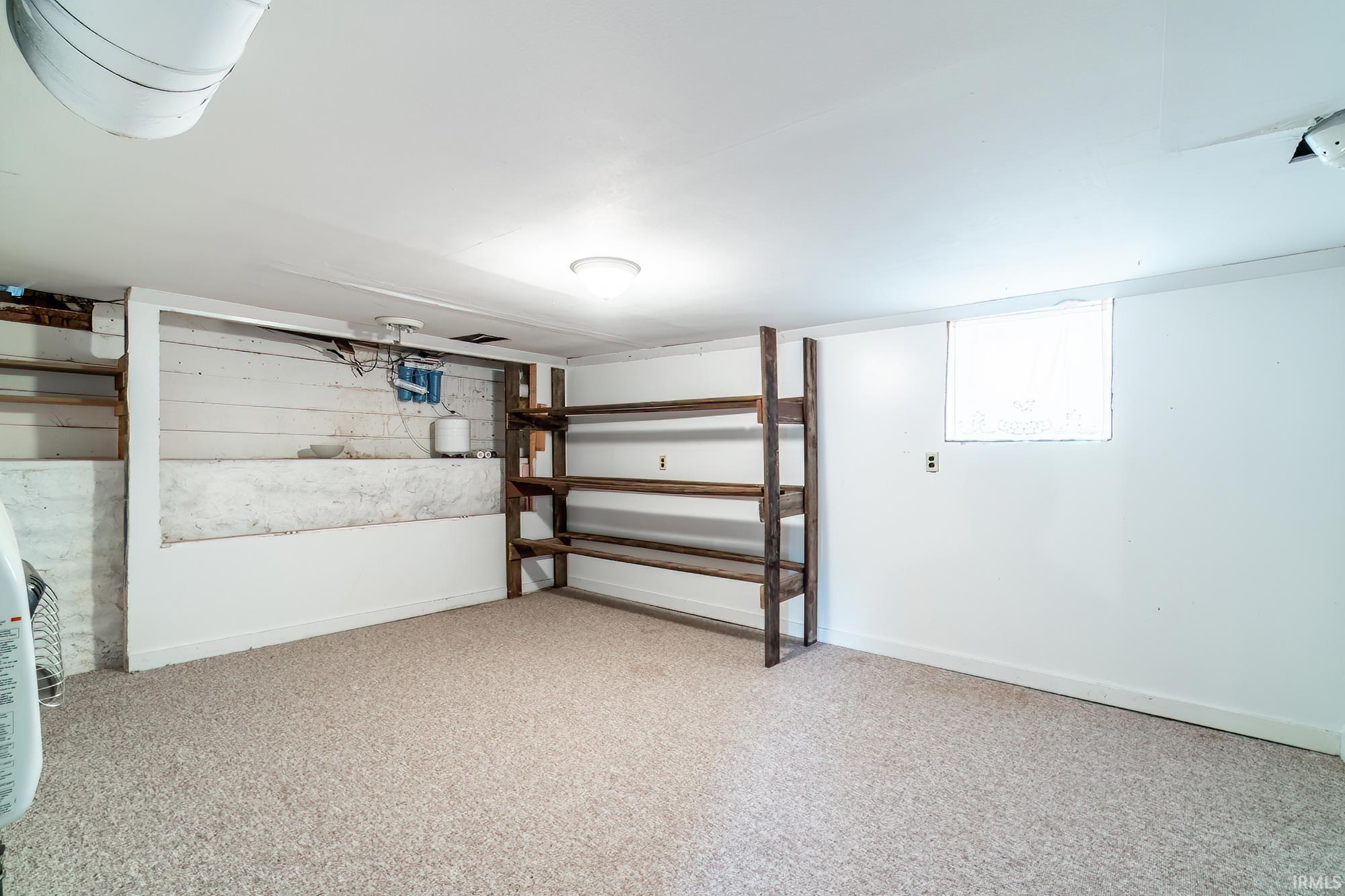 Below grade area featuring light carpet and baseboards