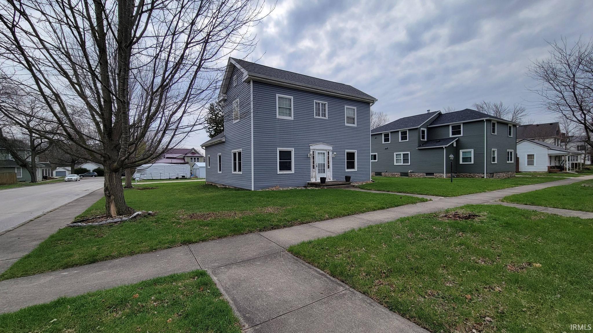 View of front facade featuring a front yard and a residential view