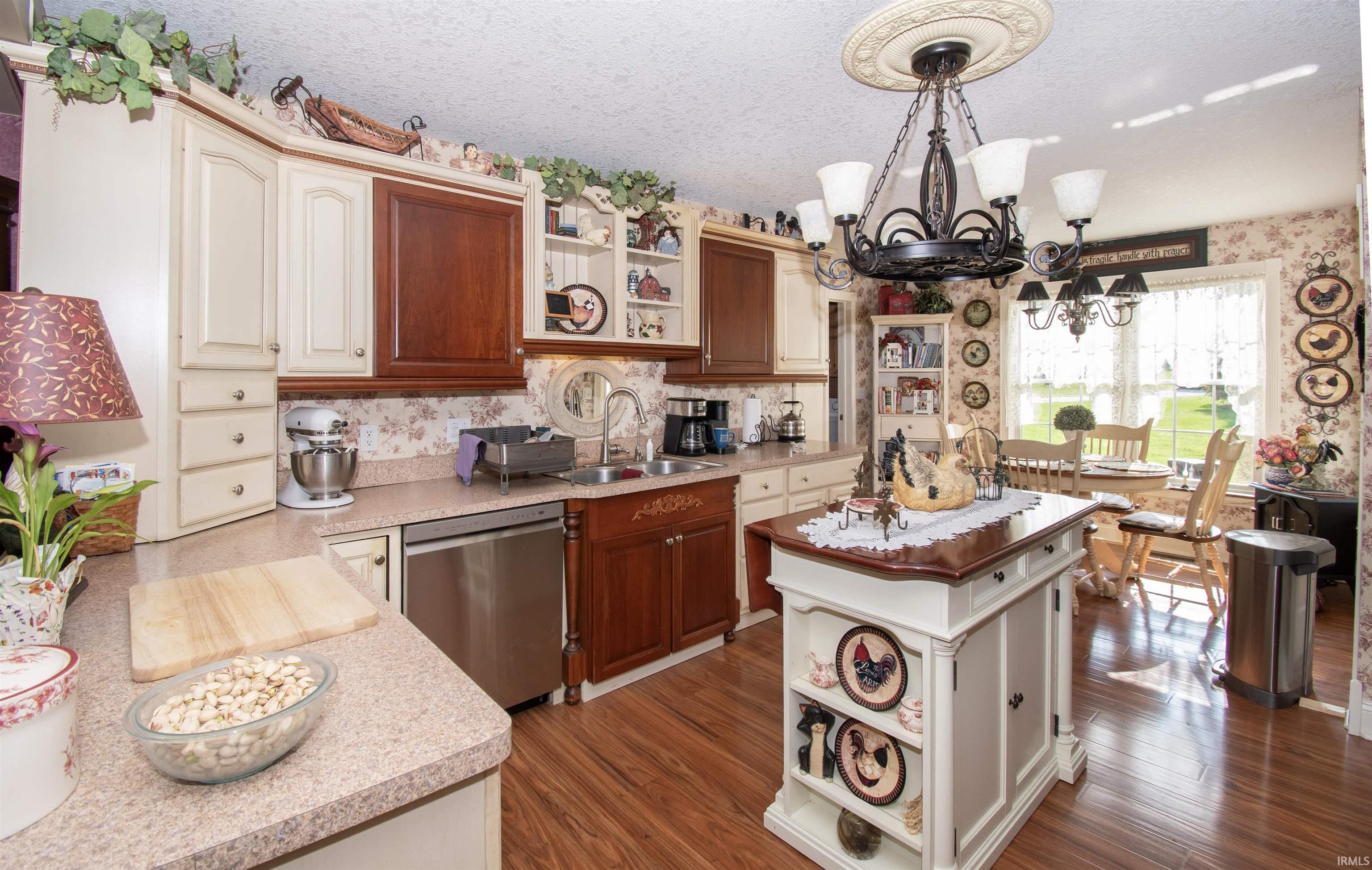 Kitchen with open shelves, wallpapered walls, stainless steel dishwasher, a chandelier, and dark wood finished floors