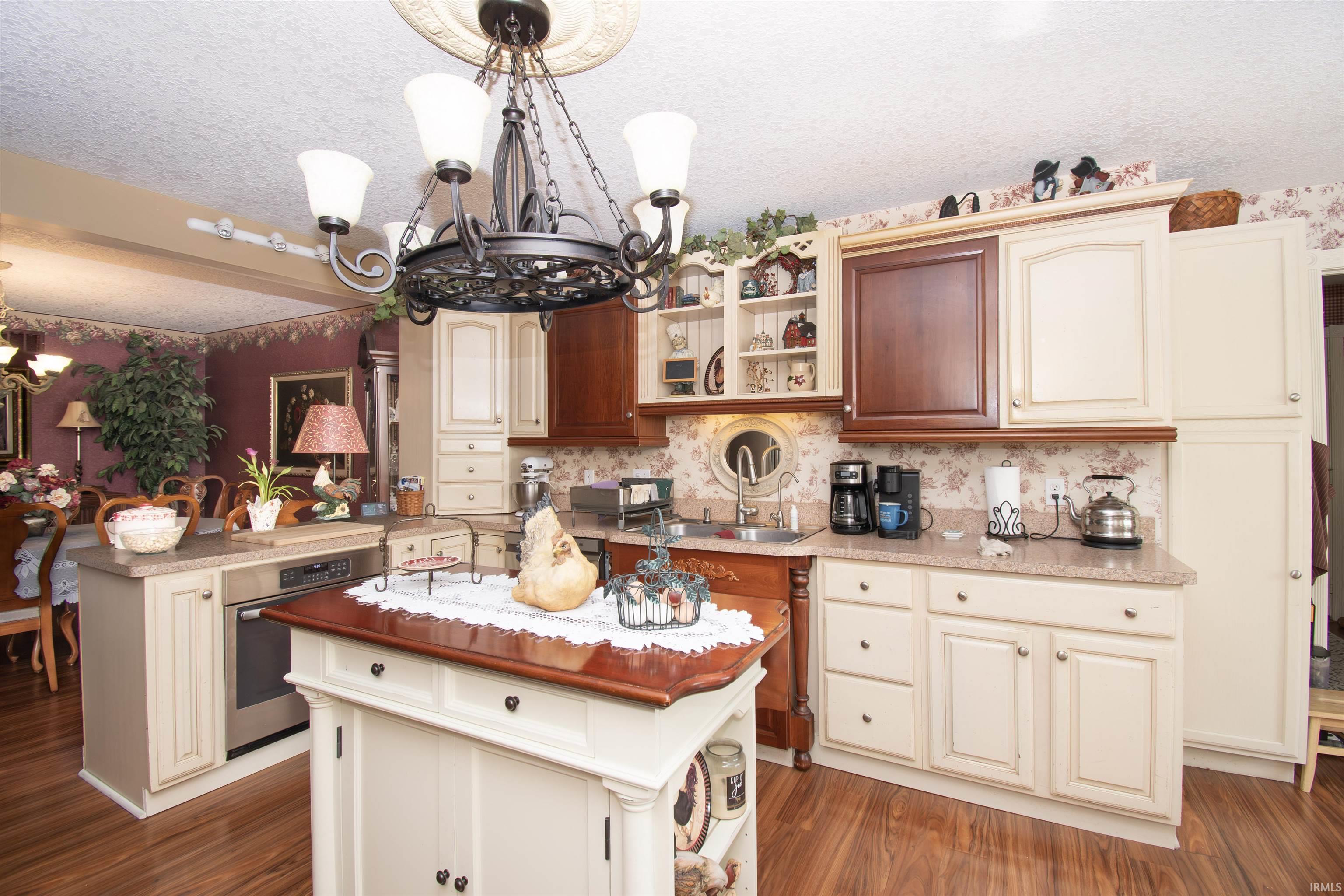 Kitchen with a center island, oven, hanging lights, a peninsula, and cream cabinetry