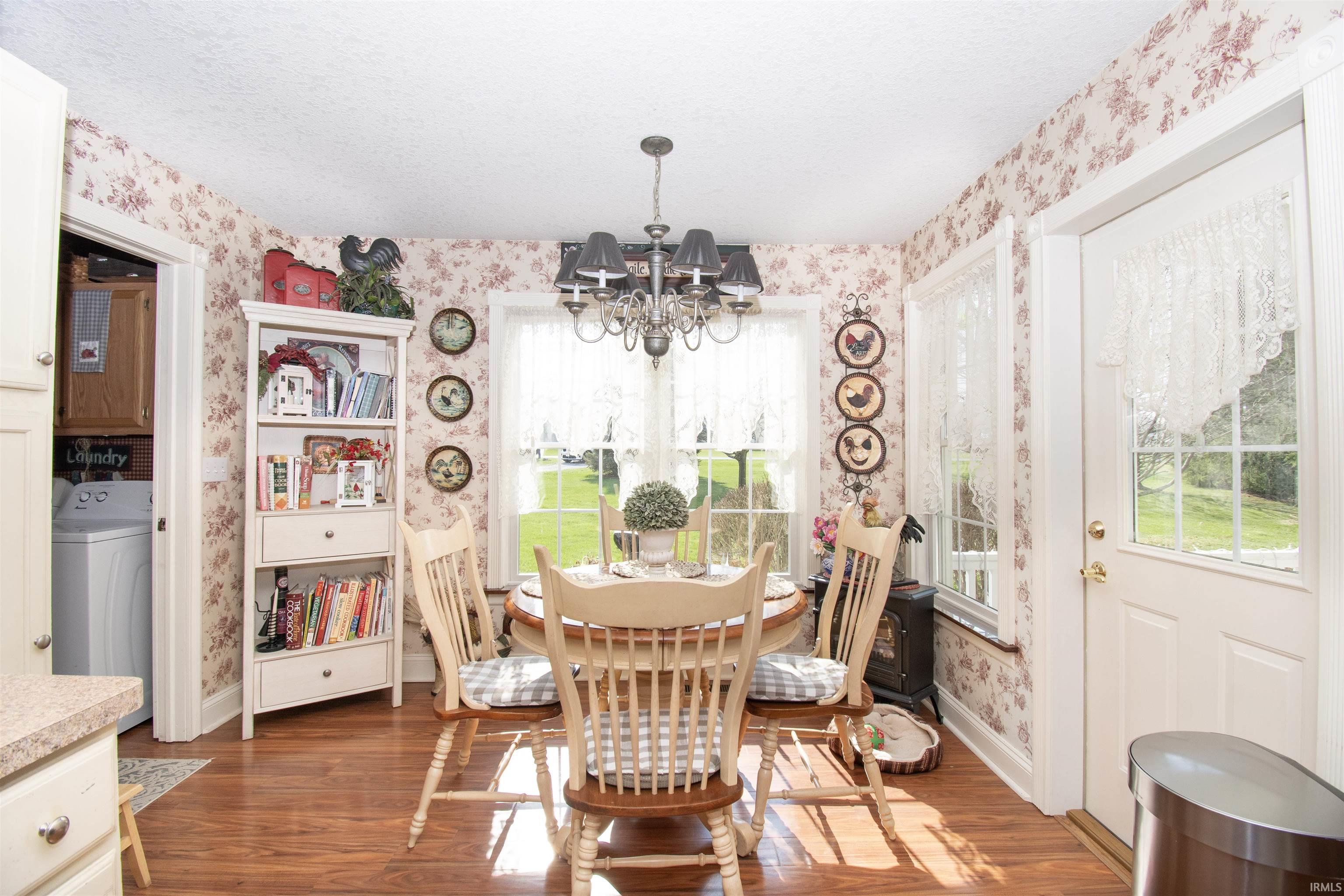 Dining room featuring washer / dryer, hanging lights, dark wood finished floors, and a textured ceiling