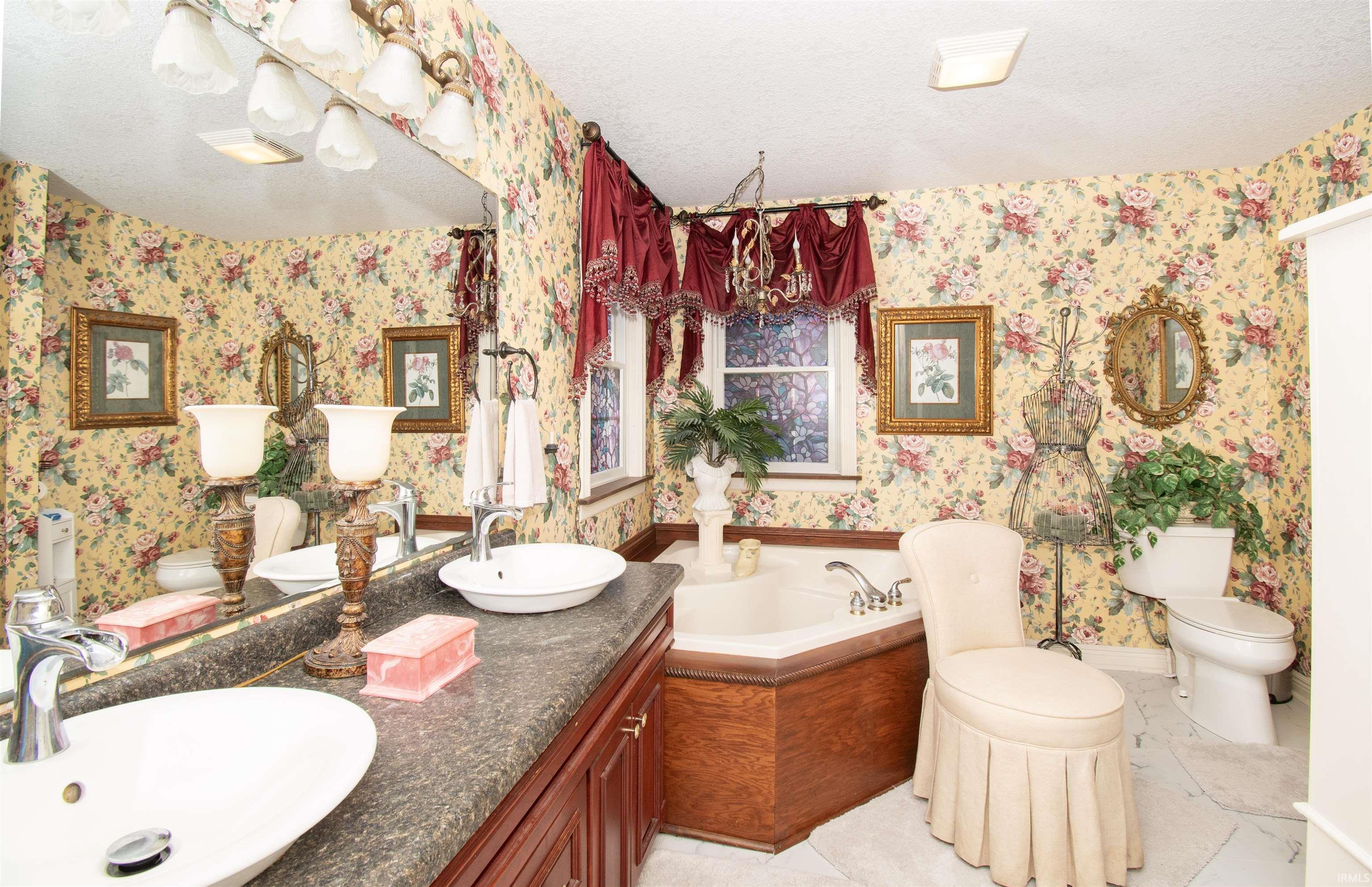 Bathroom featuring double vanity, a bath, and a textured ceiling