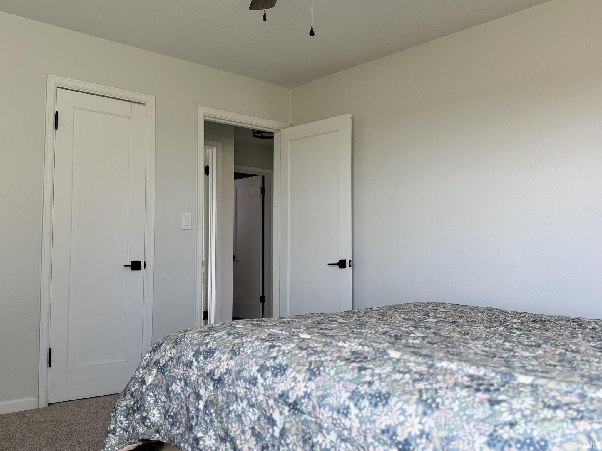 Carpeted bedroom featuring a ceiling fan and a closet